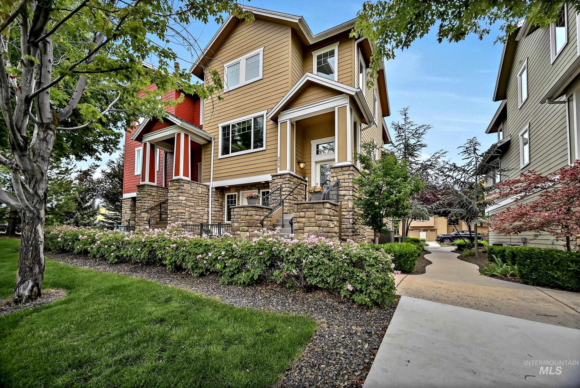 Multi-level townhome exterior featuring stone accents and a covered entry