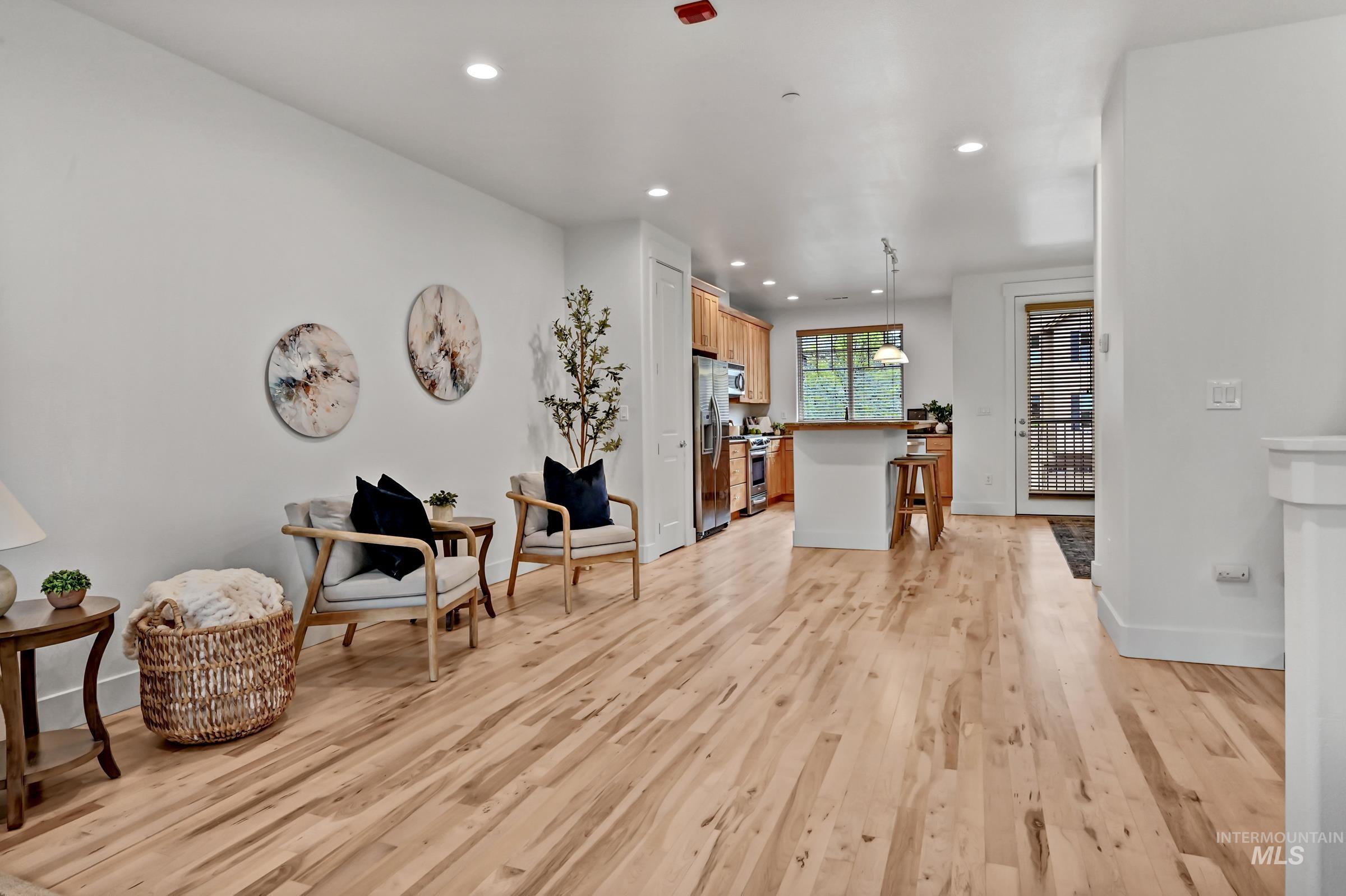 Living area with hardwood floors and open flow to kitchen and dining area. Bright, functional layout for everyday use.