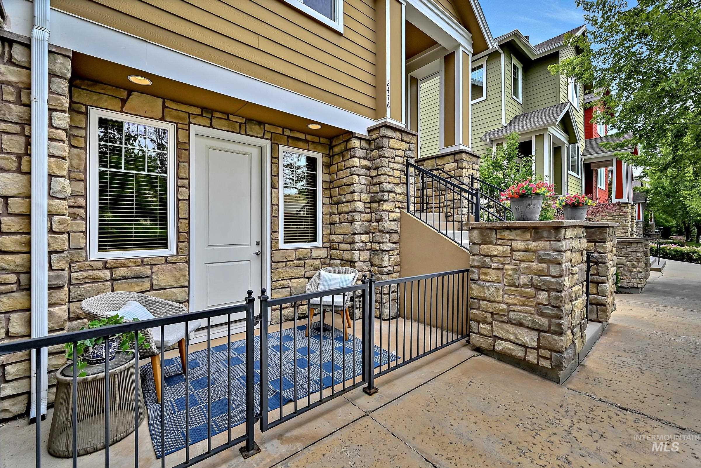 Ground-level patio off the bedroom with railing and space for outdoor seating. Great area for relaxing or dining with a view across the street toward foothills trails.