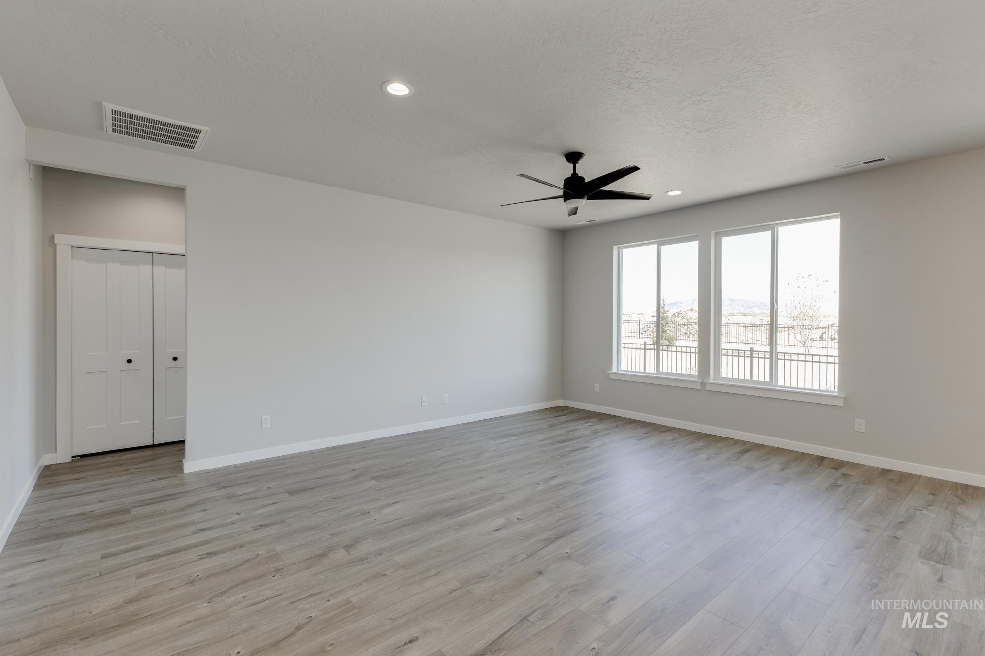 Spare room with a ceiling fan, light wood finished floors, recessed lighting, and a textured ceiling