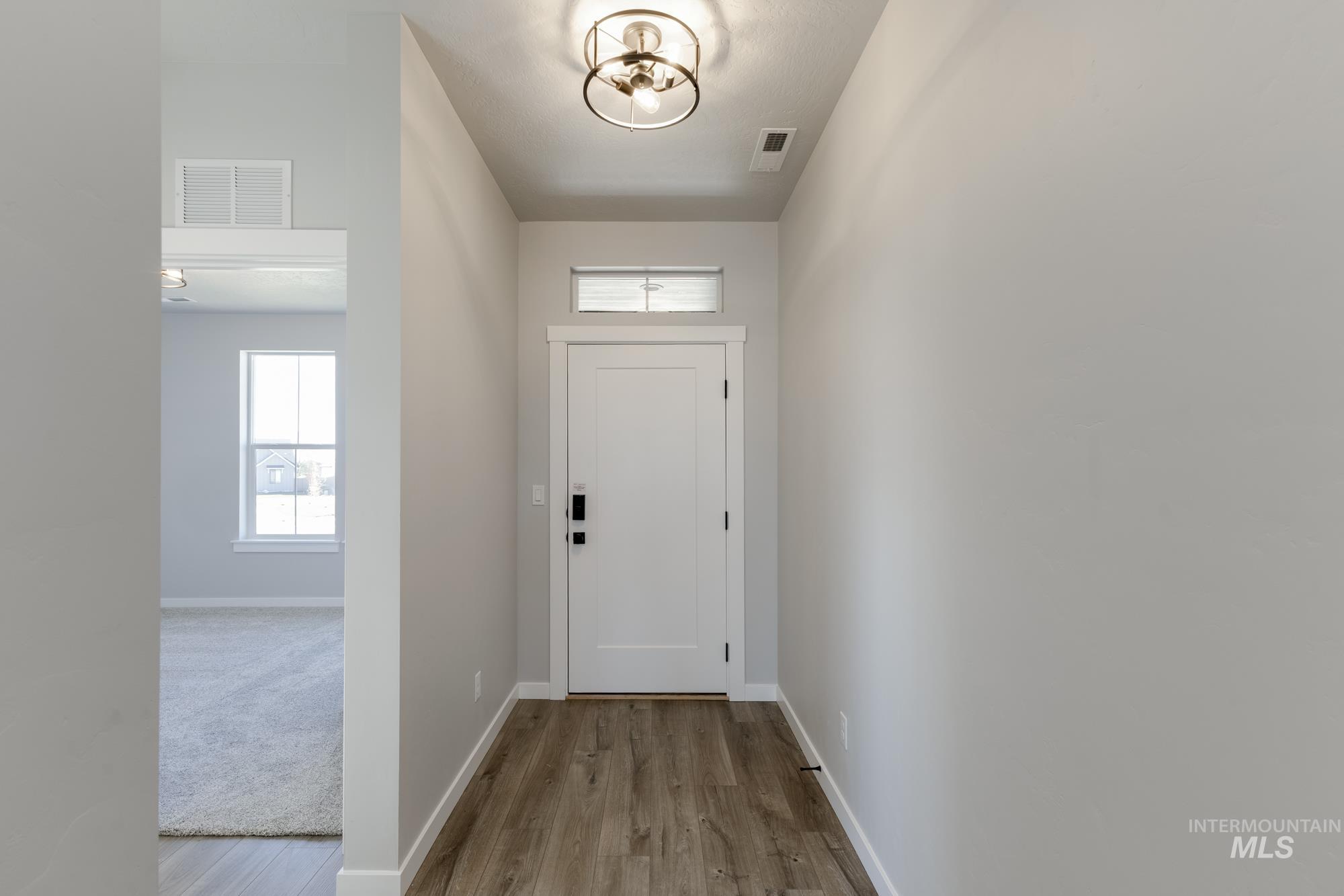 Doorway to outside with healthy amount of natural light and wood finished floors