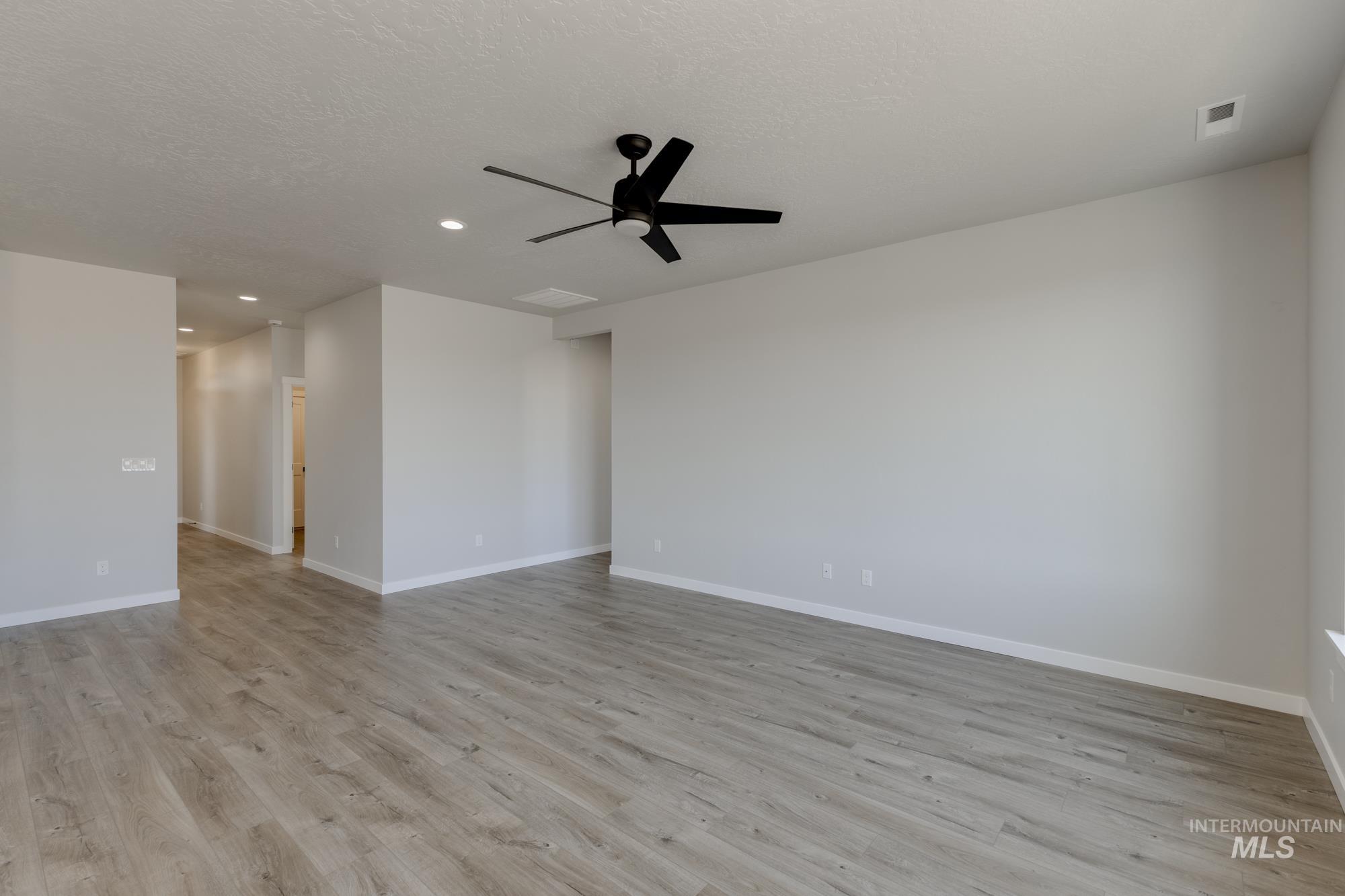 Unfurnished room with light wood-type flooring, ceiling fan, recessed lighting, and a textured ceiling