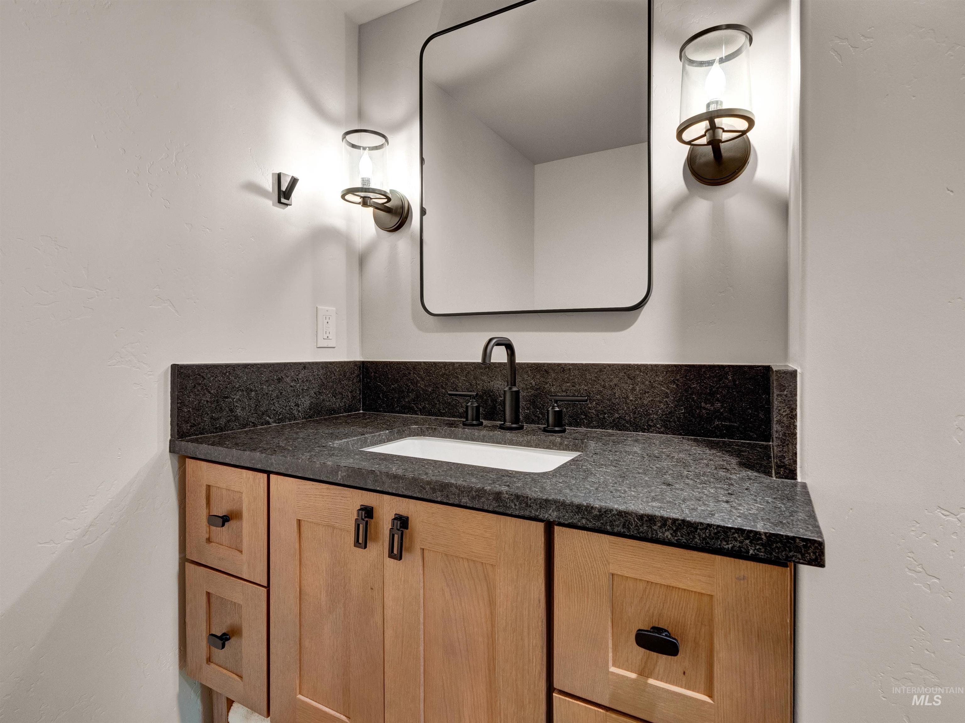 Bathroom featuring vanity and a textured wall