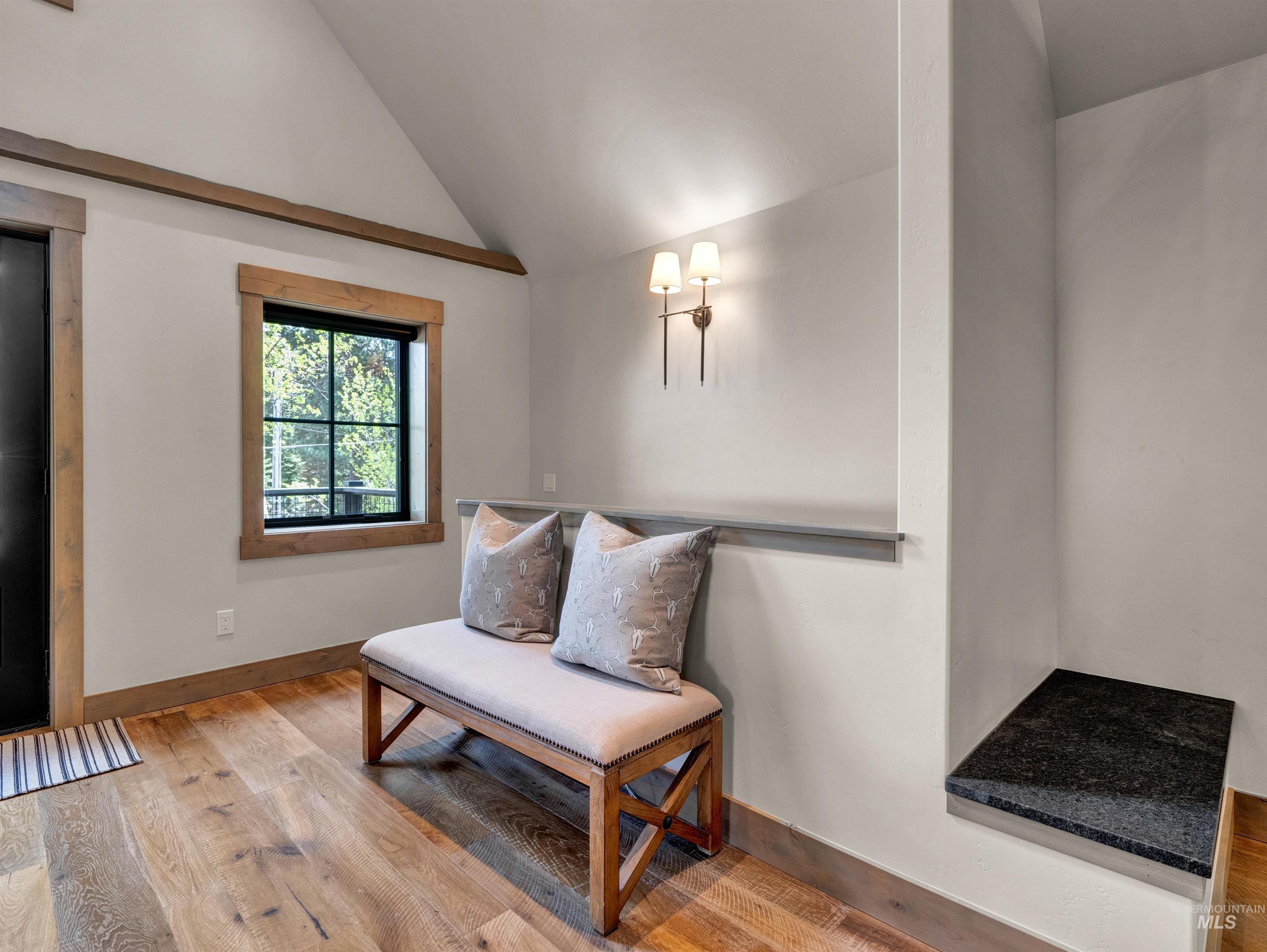 Sitting room featuring hardwood / wood-style flooring and vaulted ceiling