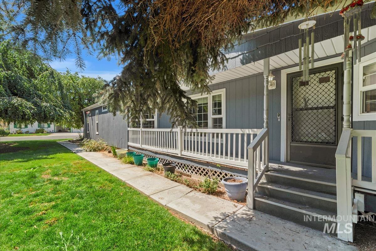 View of front facade featuring covered porch and a front yard