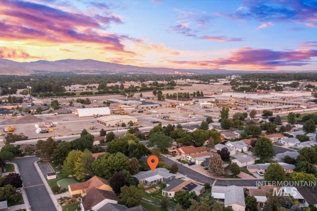 Aerial view of property's location with a mountain backdrop and nearby suburban area