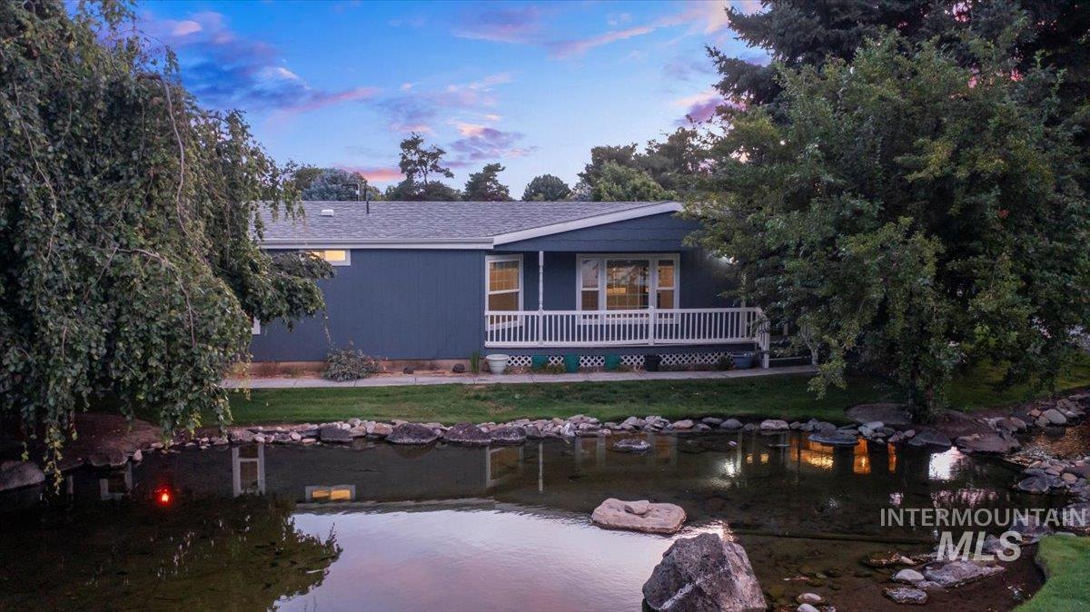 View of front of property with a garden pond and a front yard