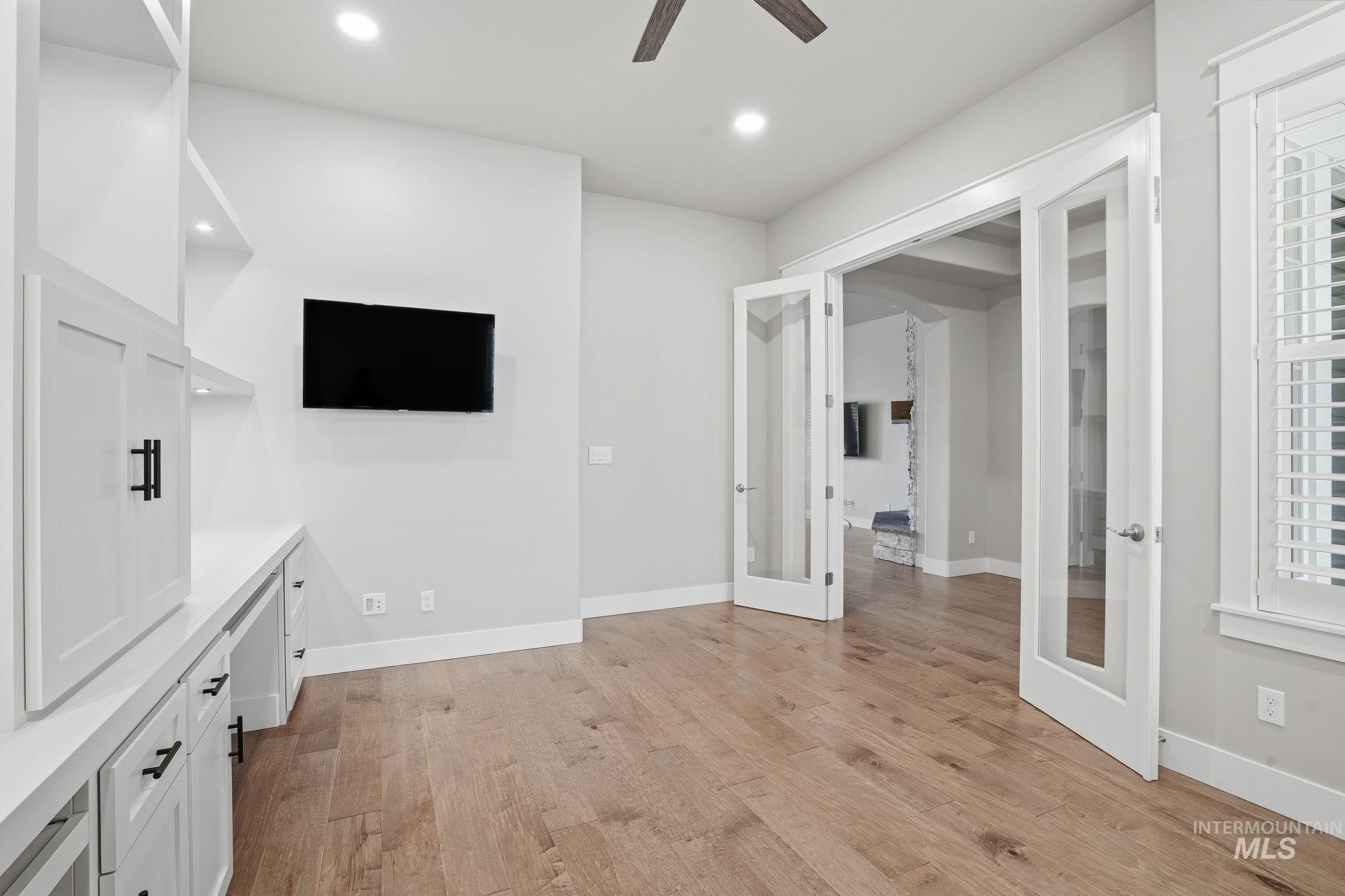 Unfurnished living room with light wood-style flooring, french doors, recessed lighting, and ceiling fan