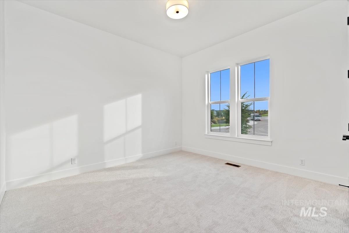 Unfurnished room featuring light colored carpet and baseboards