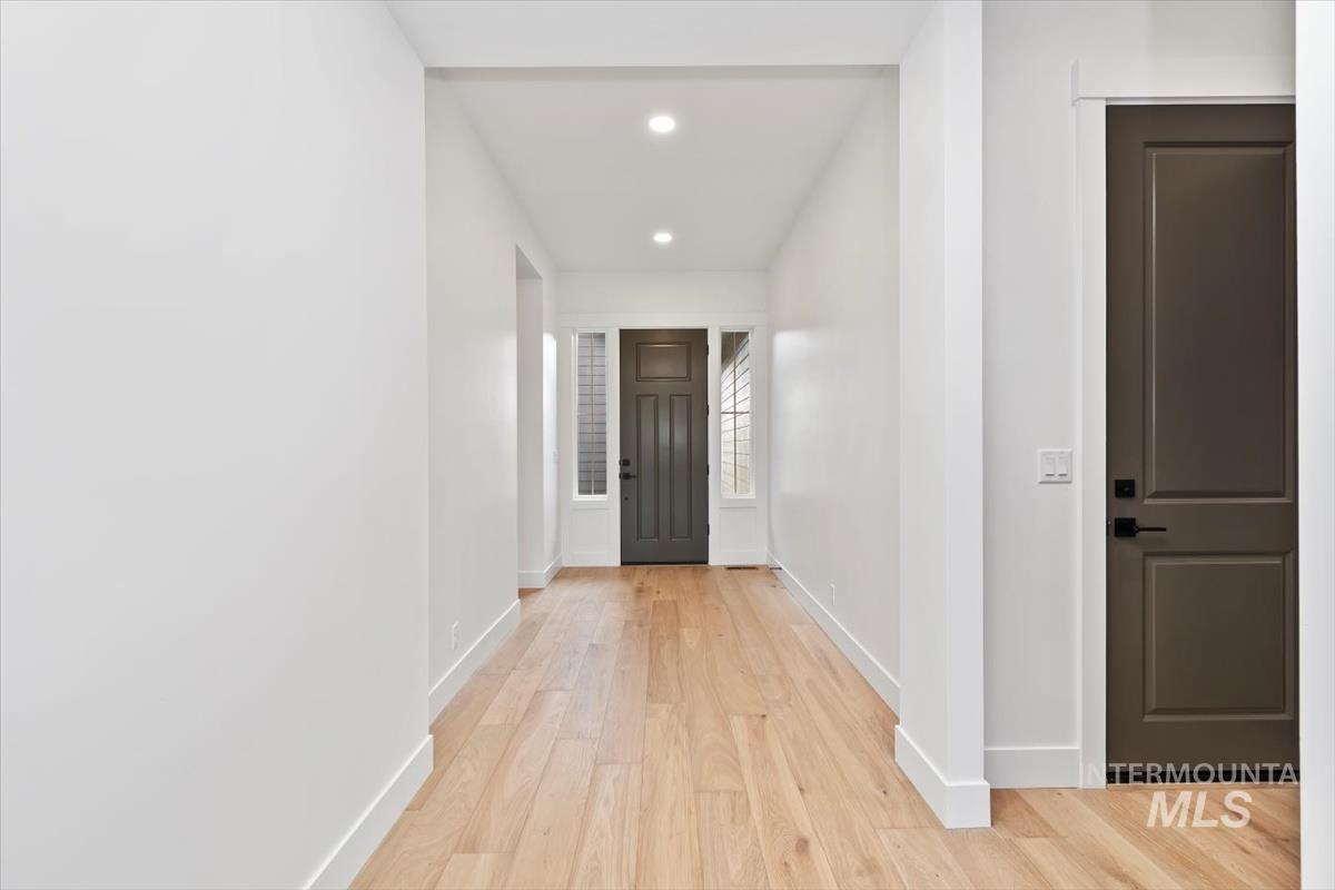 Hallway with recessed lighting and light wood-style floors