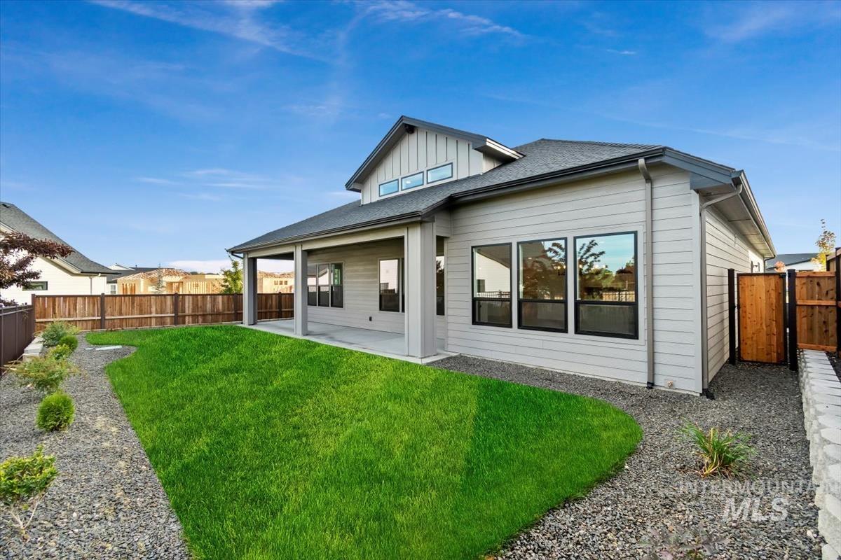 Rear view of house with a patio, a fenced backyard, and roof with shingles