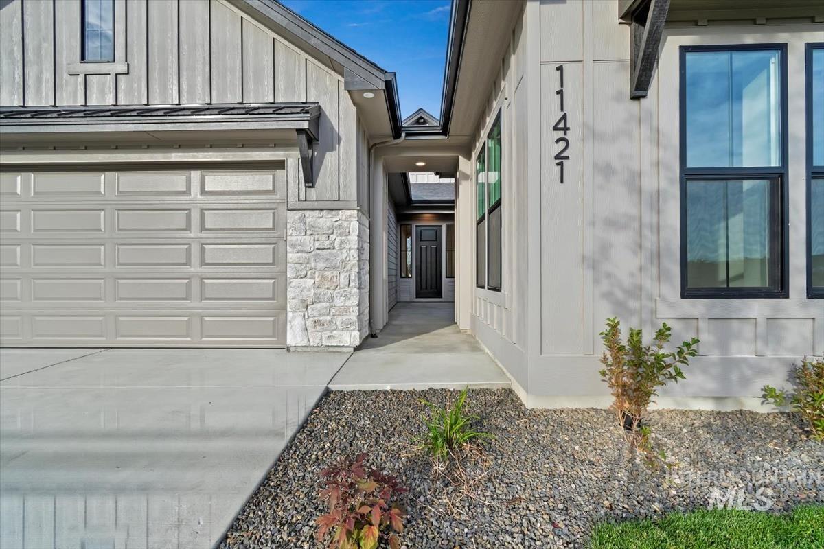 View of home's exterior featuring stone siding, a garage, and board and batten siding