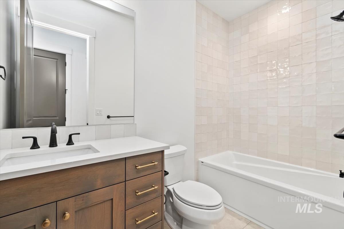 Bathroom with vanity,  shower combination, and light tile patterned flooring