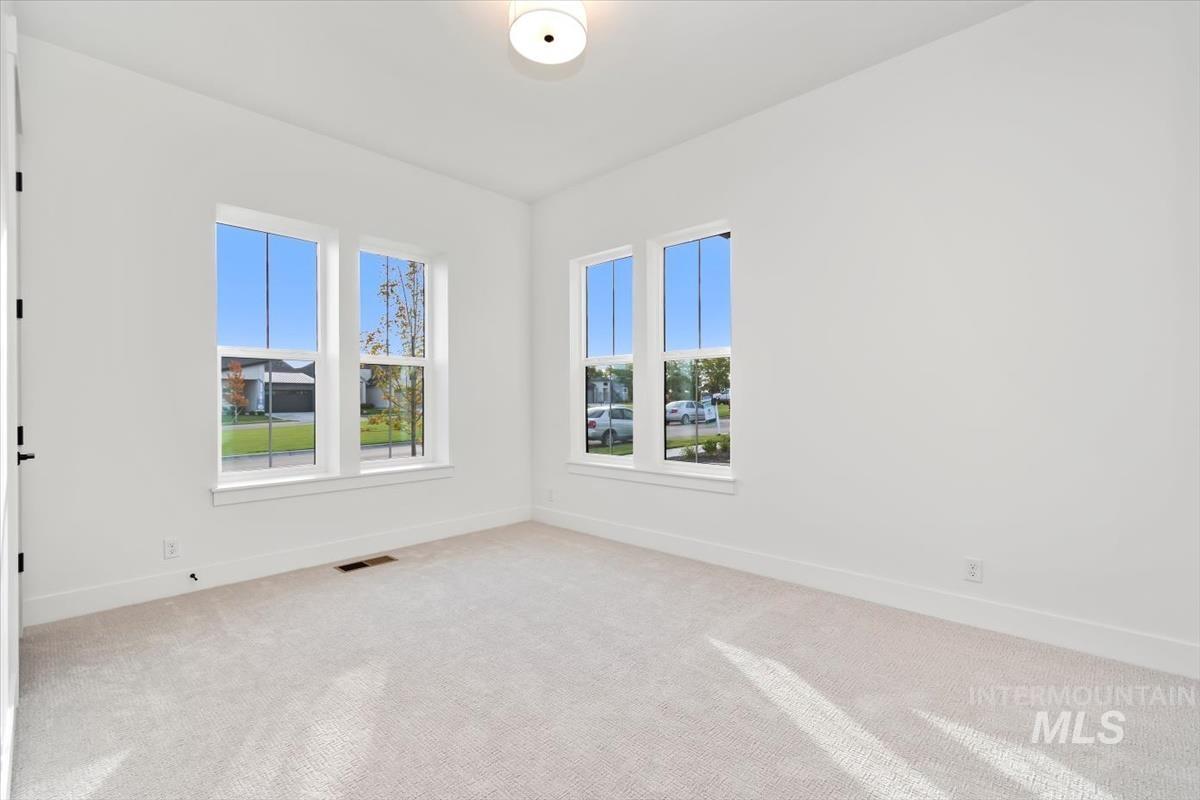 Carpeted spare room with baseboards