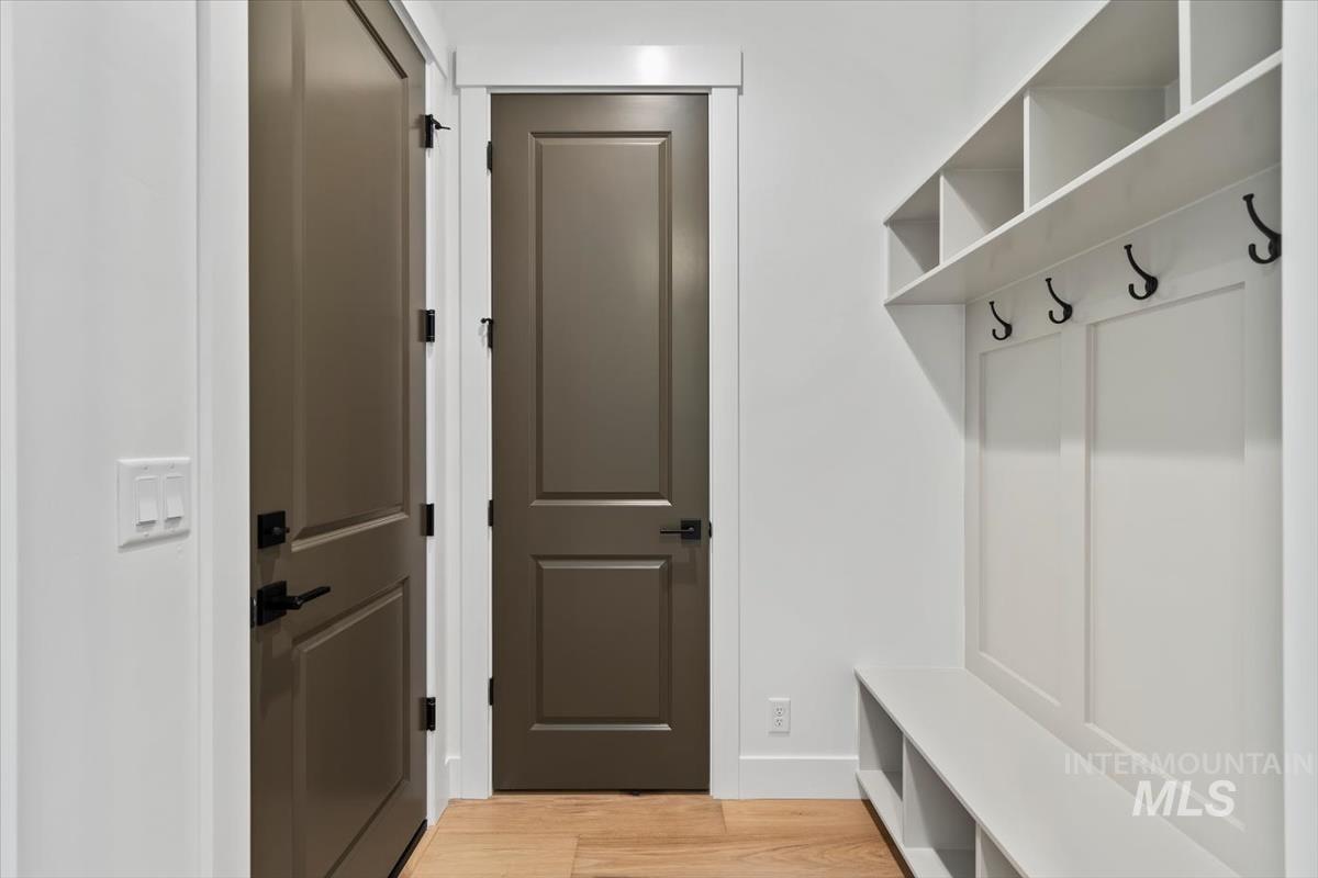 Mudroom with light wood-style floors and baseboards