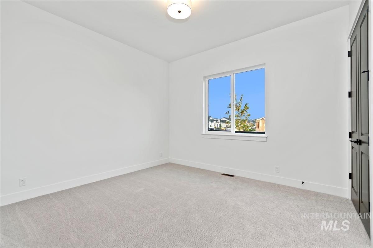 Spare room featuring light carpet and baseboards