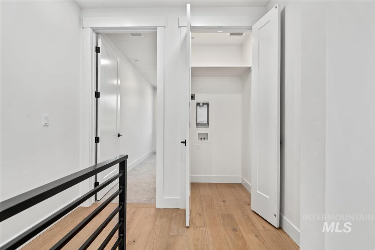 Hall with light wood-style floors and baseboards