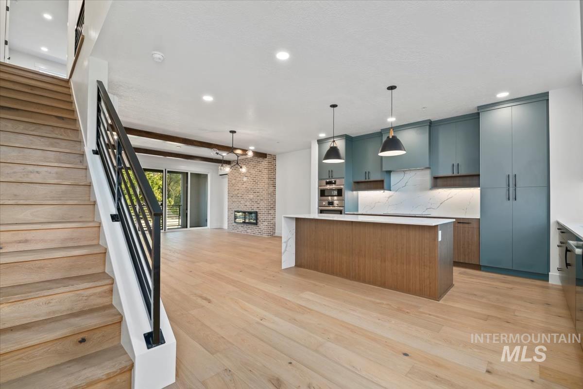 Kitchen featuring a center island, open floor plan, modern cabinets, light wood finished floors, and recessed lighting
