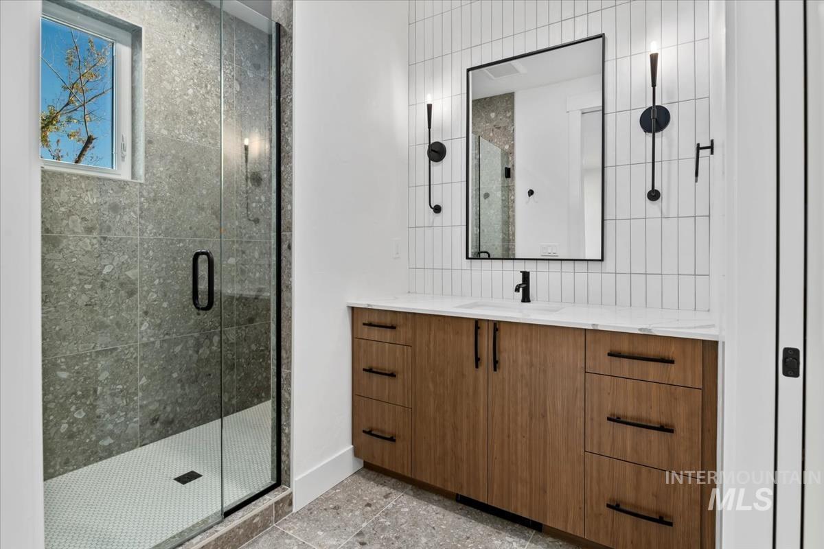 Full bath with a stall shower and vanity