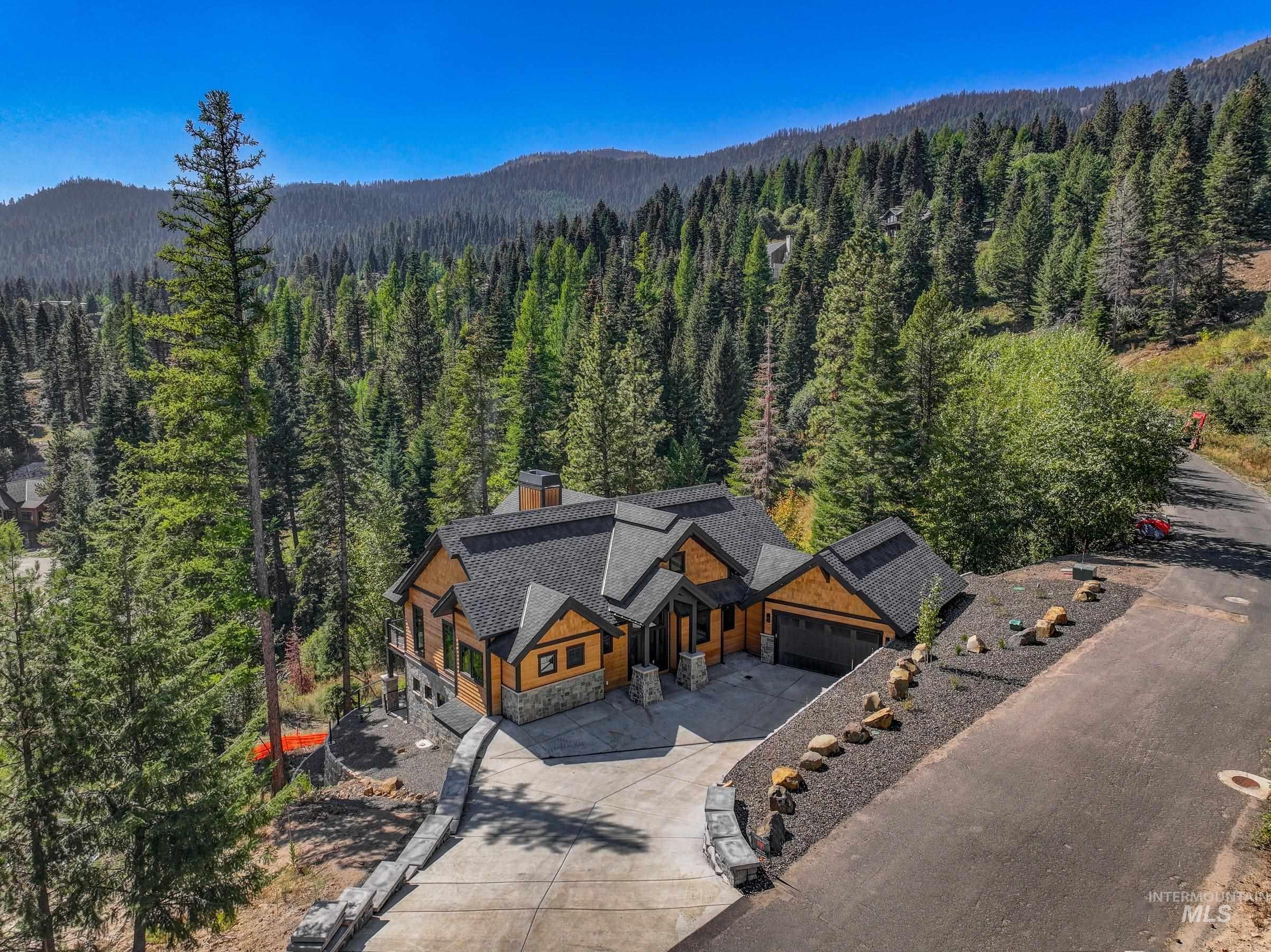 Aerial view of property and surrounding area with a heavily wooded area