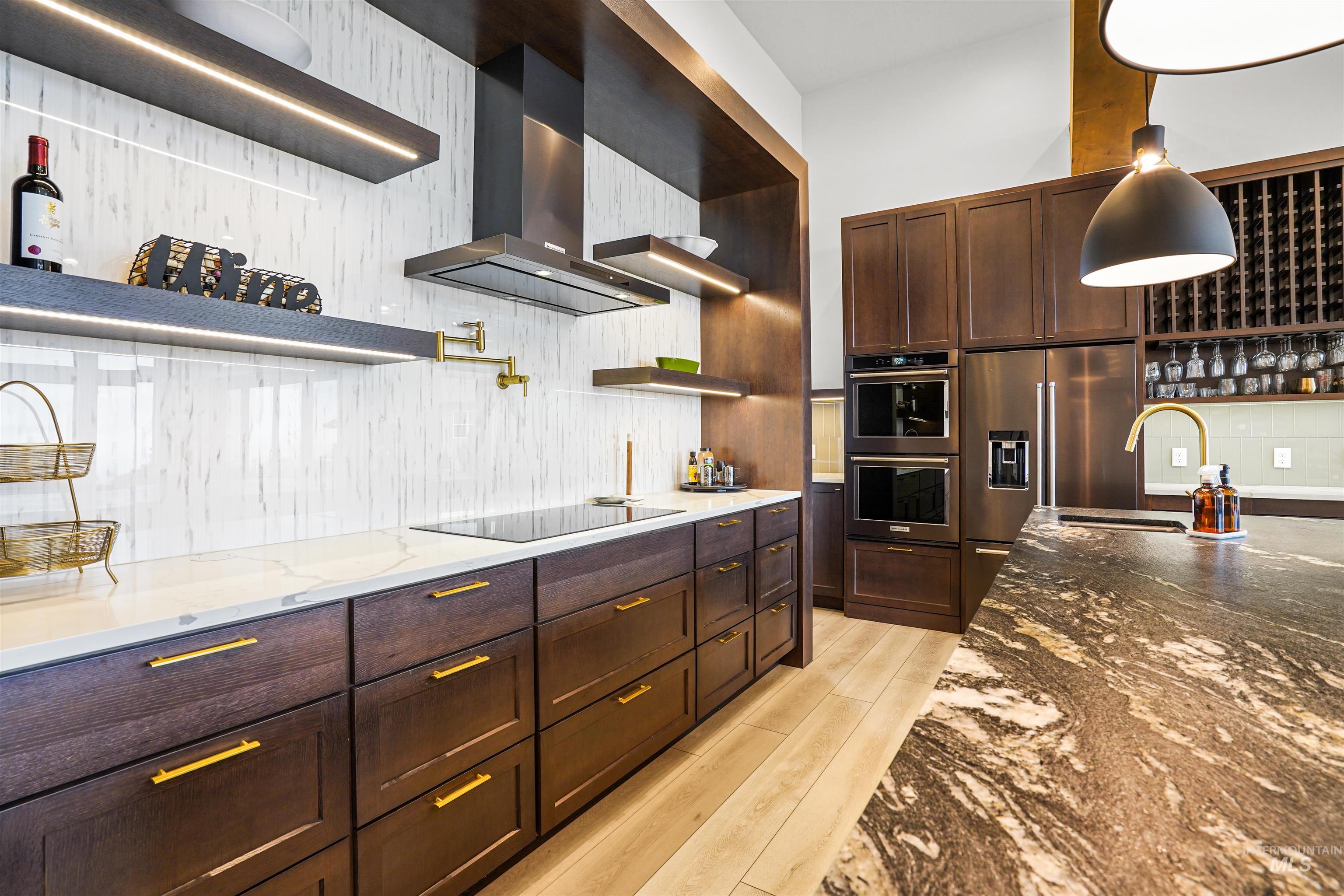 Kitchen featuring open shelves, dark stone counters, wall chimney exhaust hood, and dark brown cabinets
