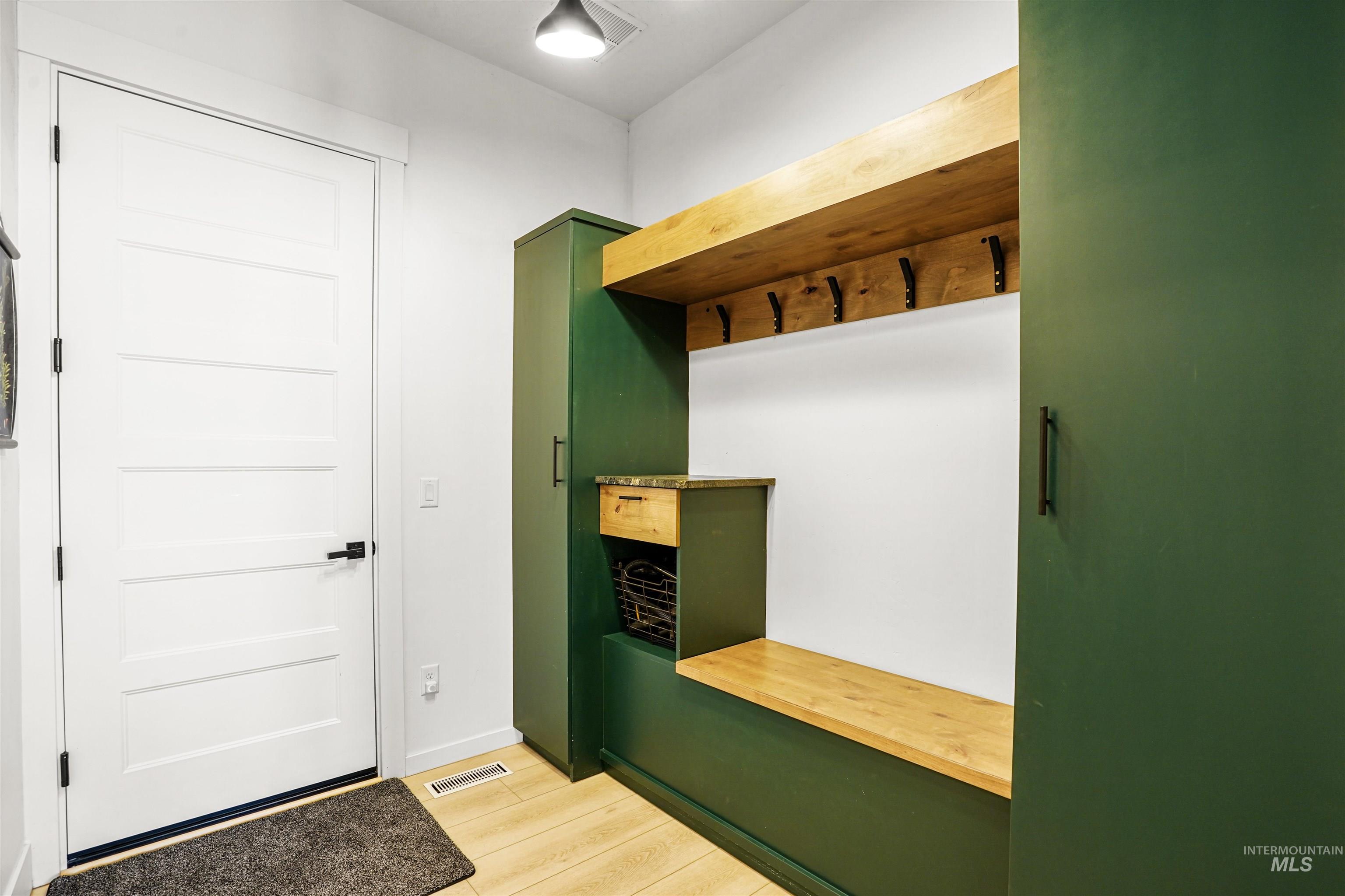 Mudroom featuring light wood-style floors and baseboards