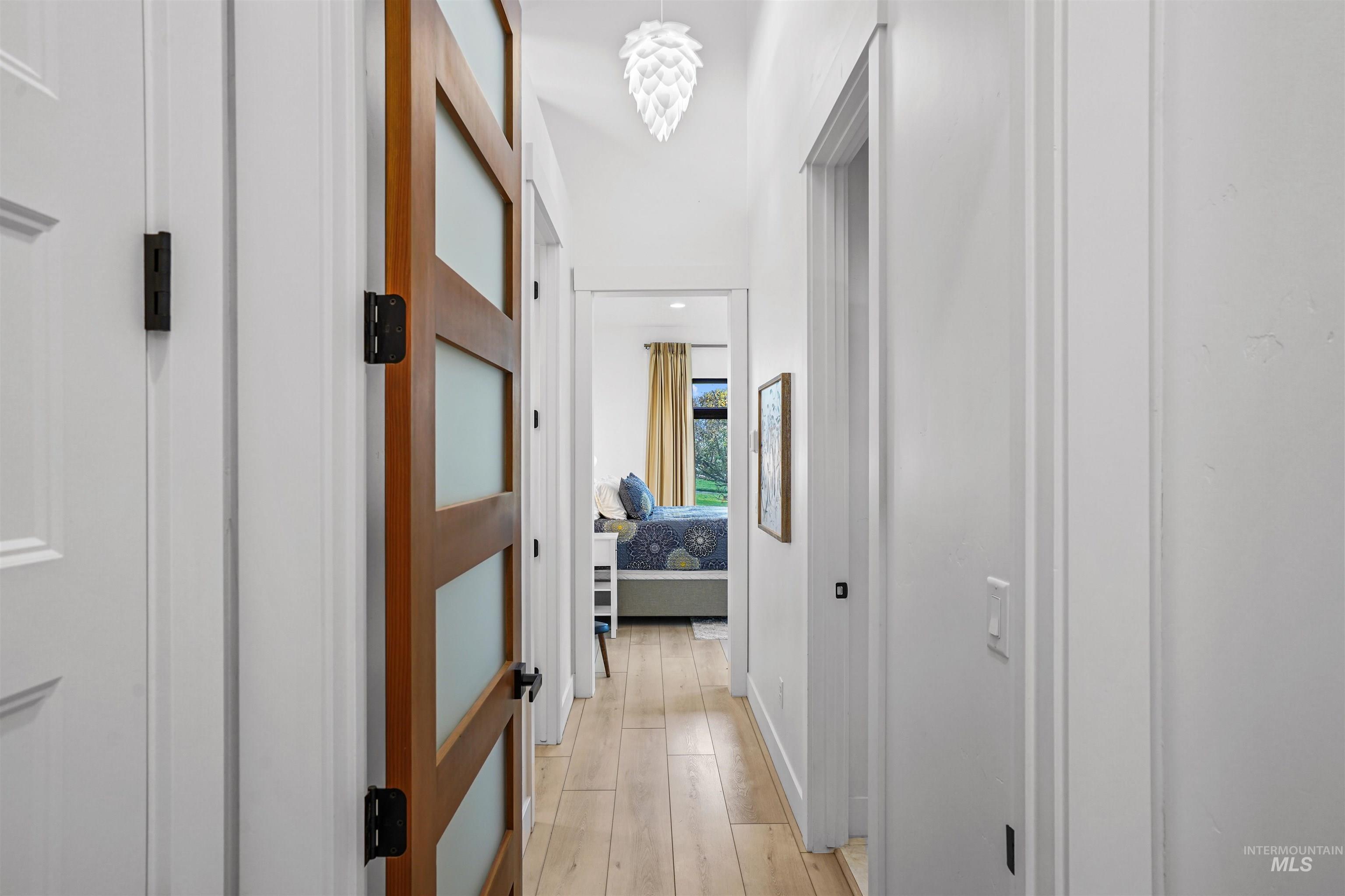 Hallway featuring light wood-type flooring and baseboards