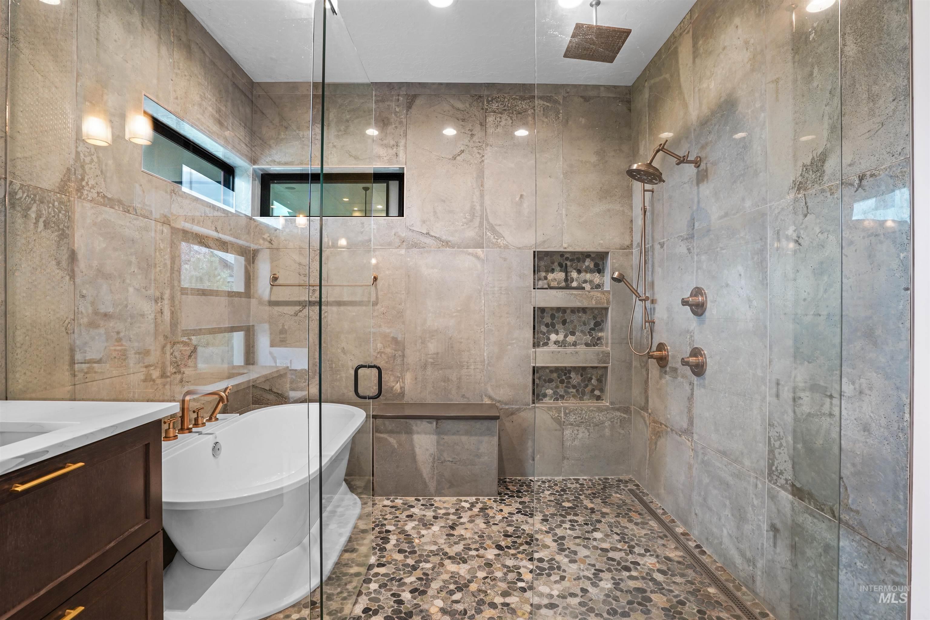 Bathroom featuring a shower stall, a freestanding tub, vanity, and recessed lighting