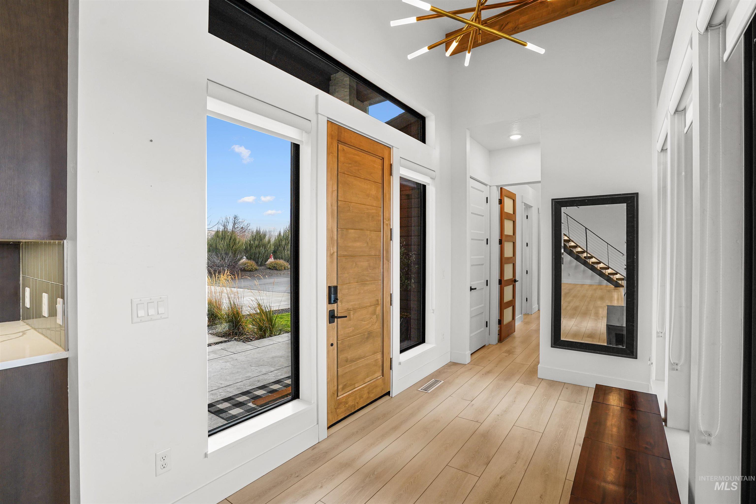 Foyer entrance with a chandelier and light wood-type flooring