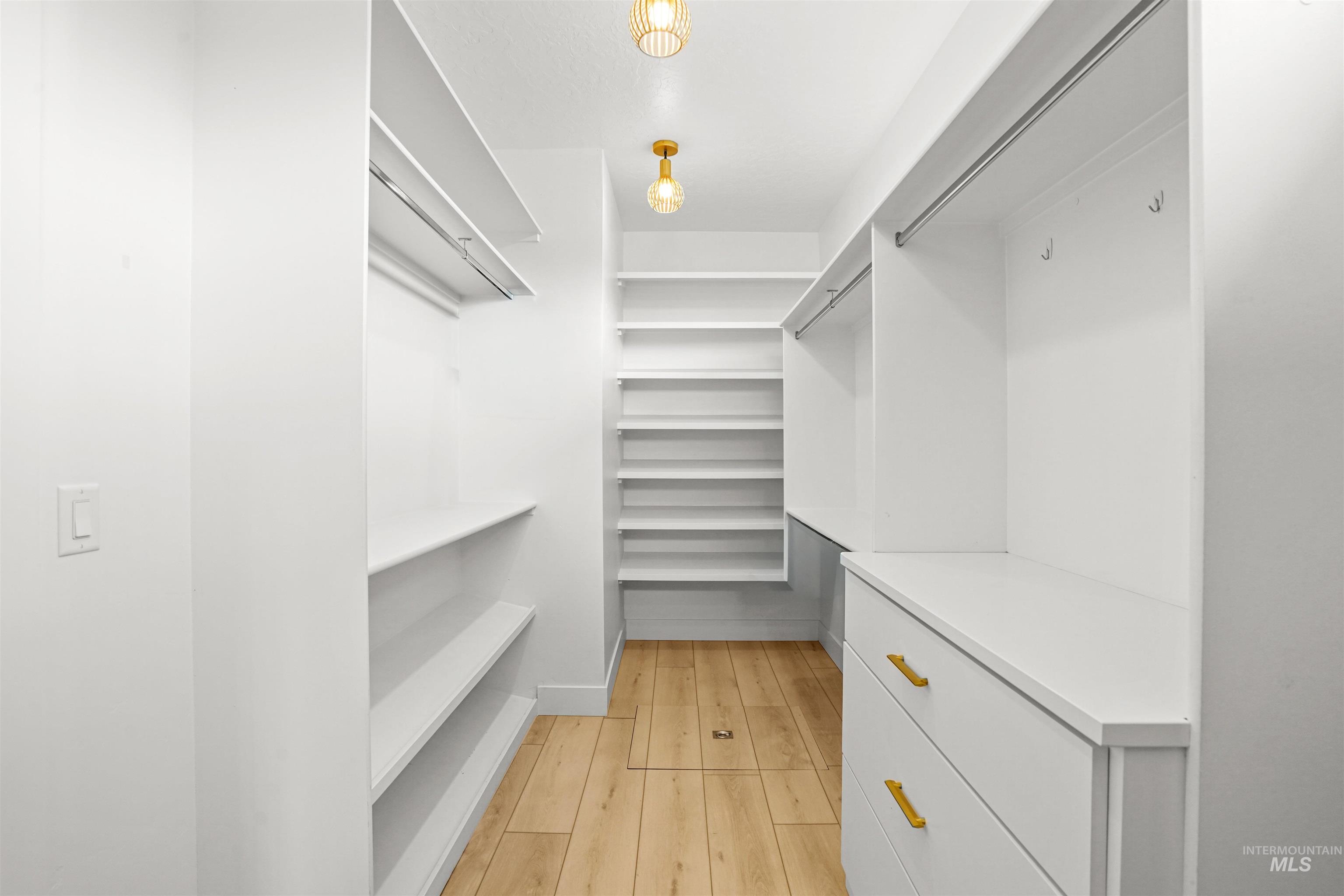 Walk in closet with light wood-type flooring