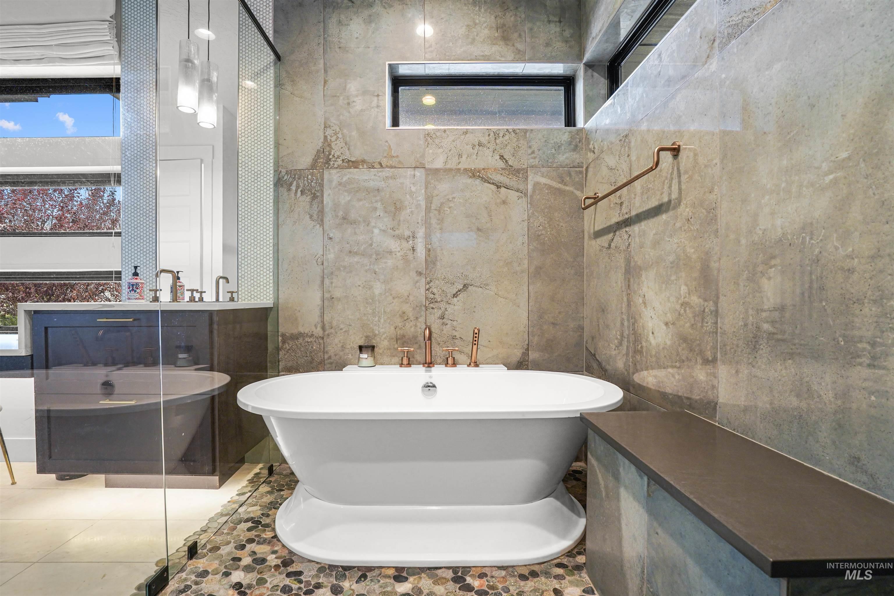 Bathroom with a soaking tub, vanity, tile patterned floors, and tile walls
