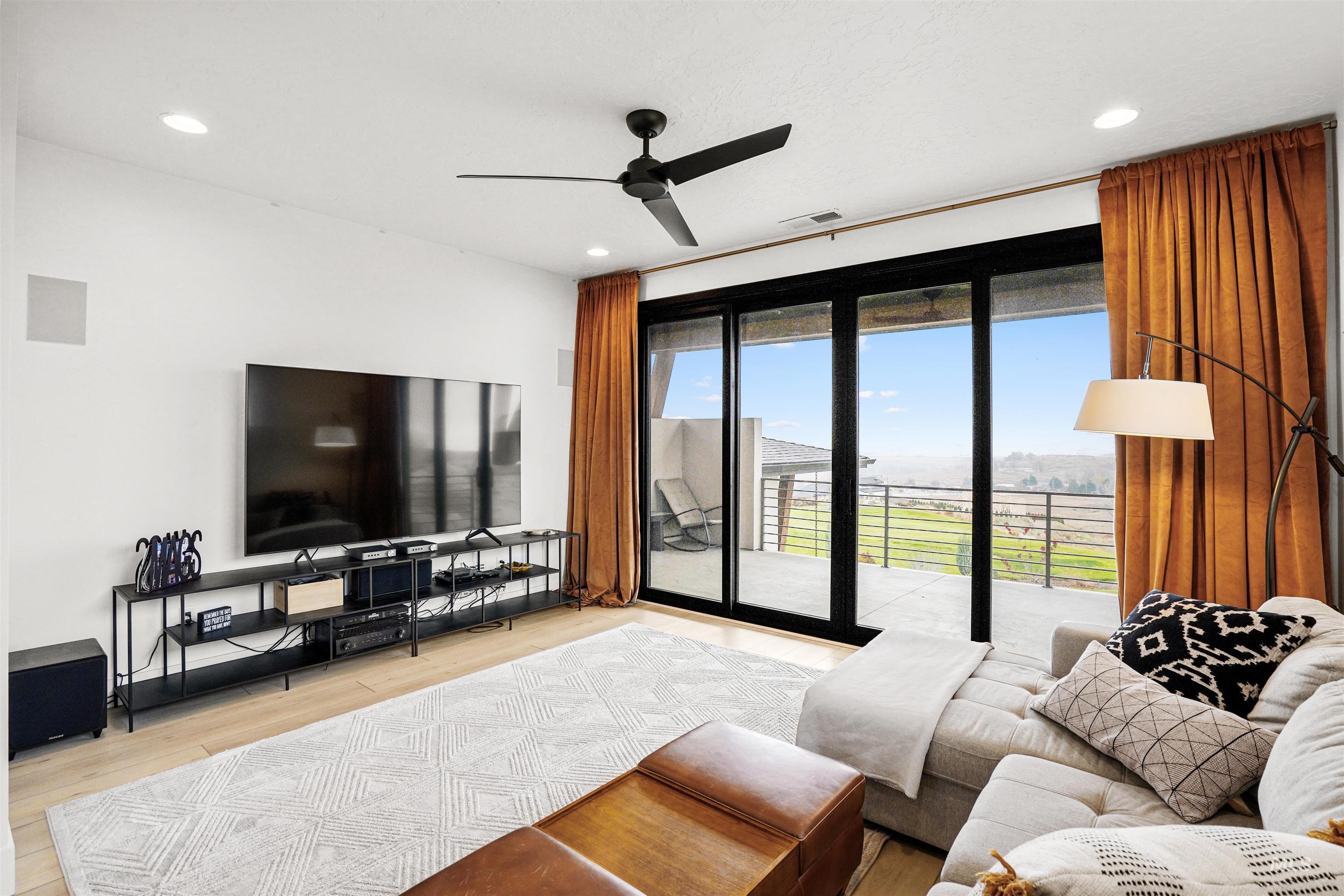 Living room with a ceiling fan, light wood-style floors, and recessed lighting