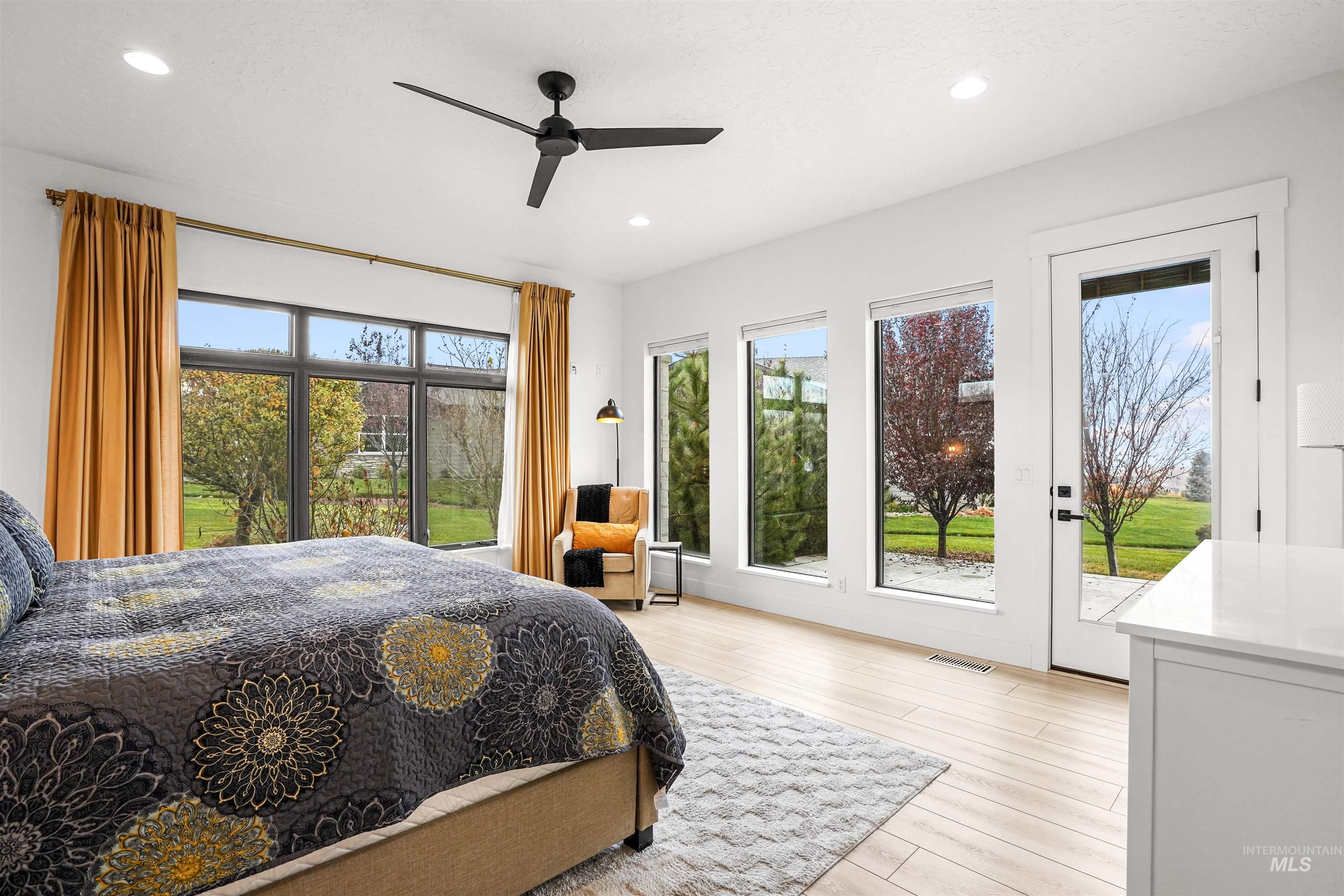 Bedroom with access to exterior, light wood finished floors, multiple windows, a ceiling fan, and recessed lighting