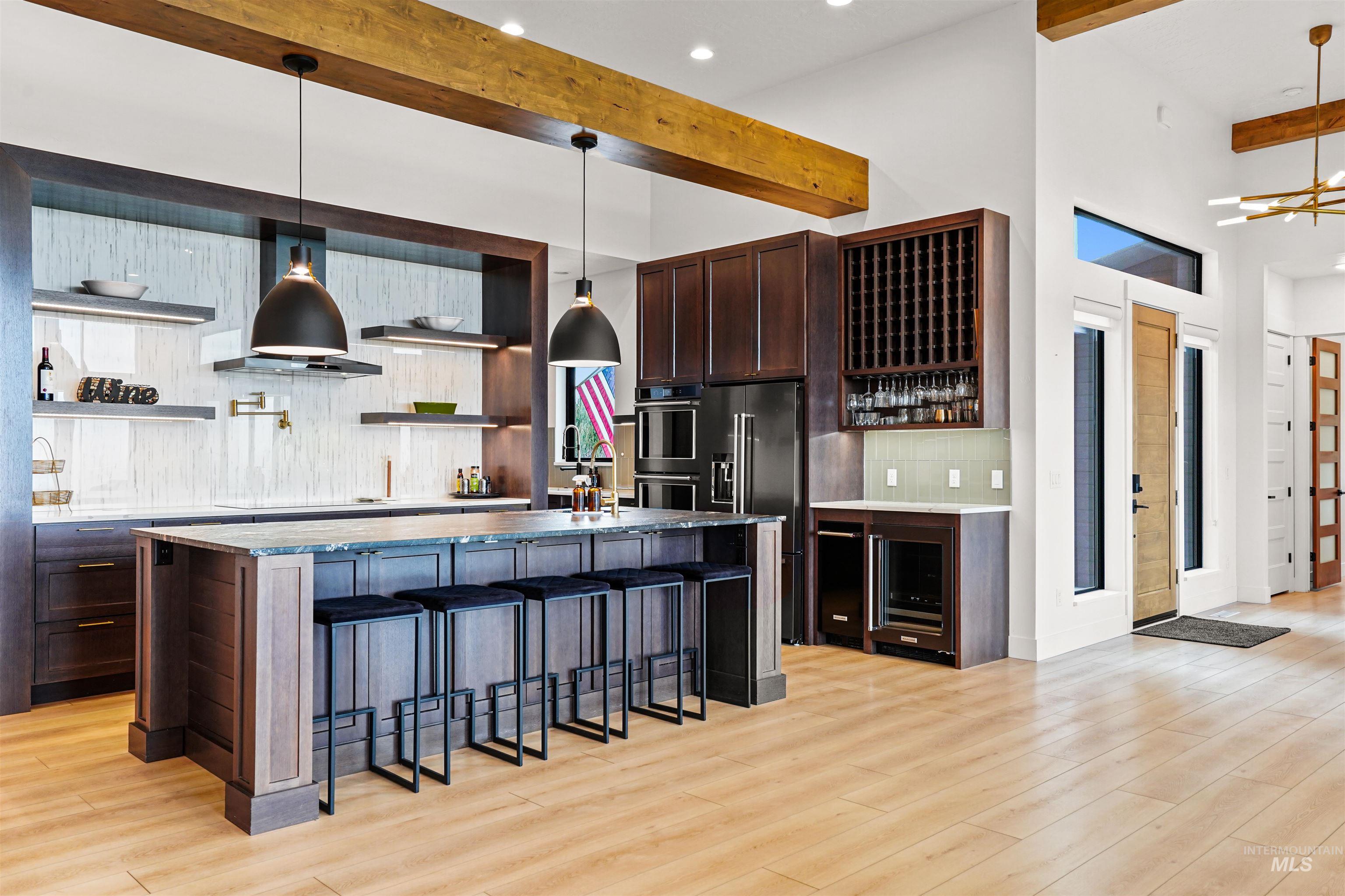 Kitchen with open shelves, dark brown cabinetry, a breakfast bar area, tasteful backsplash, and beamed ceiling