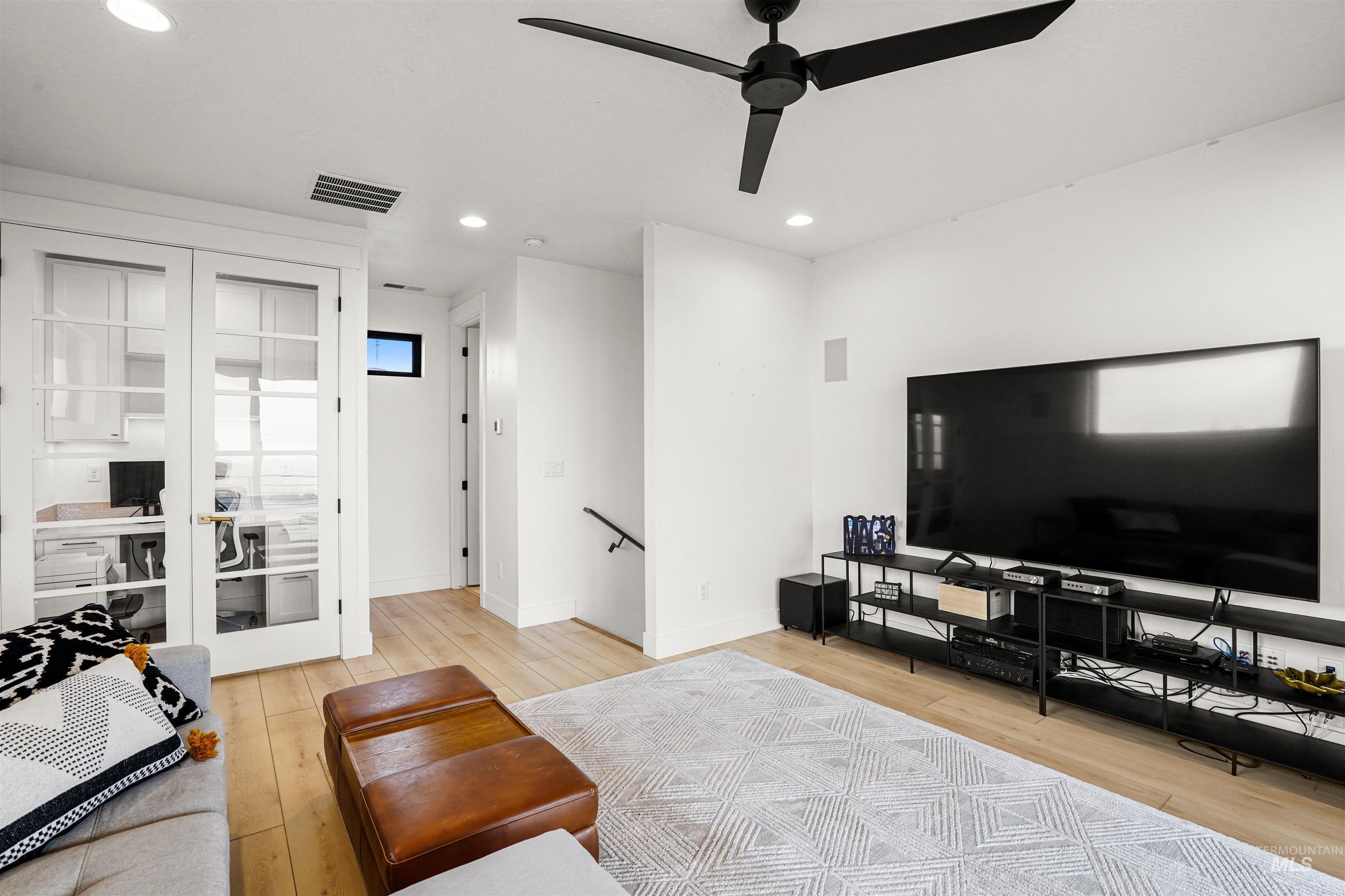 Living area with light wood finished floors, recessed lighting, and a ceiling fan