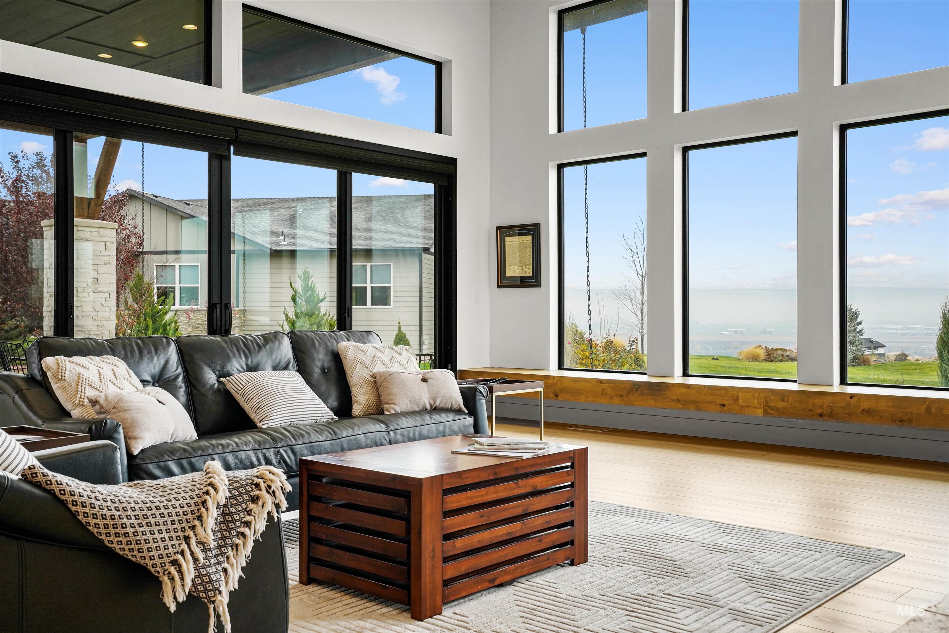 Living room featuring wood finished floors, healthy amount of natural light, and a towering ceiling