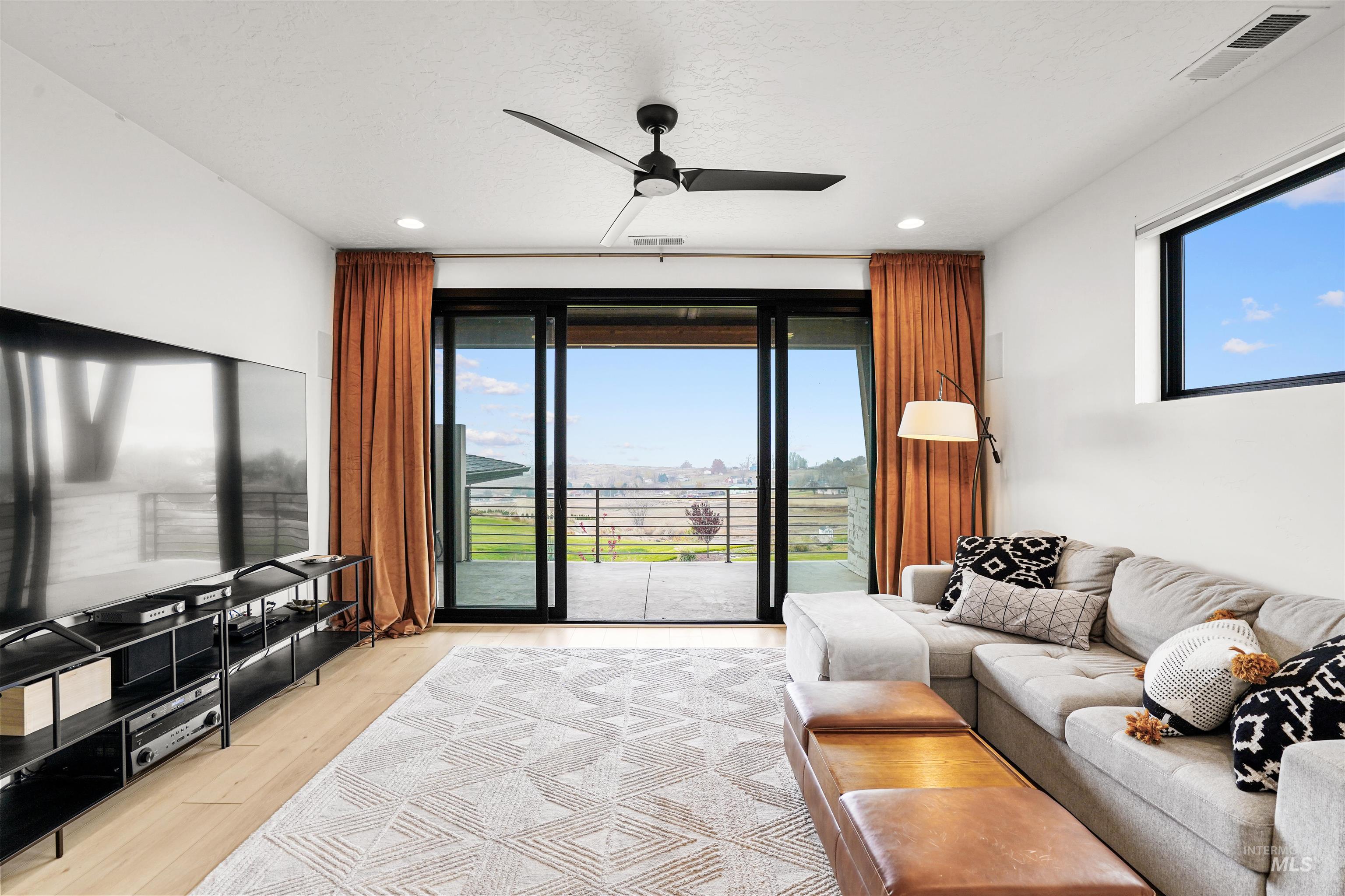 Living area with light wood-type flooring, plenty of natural light, ceiling fan, and recessed lighting