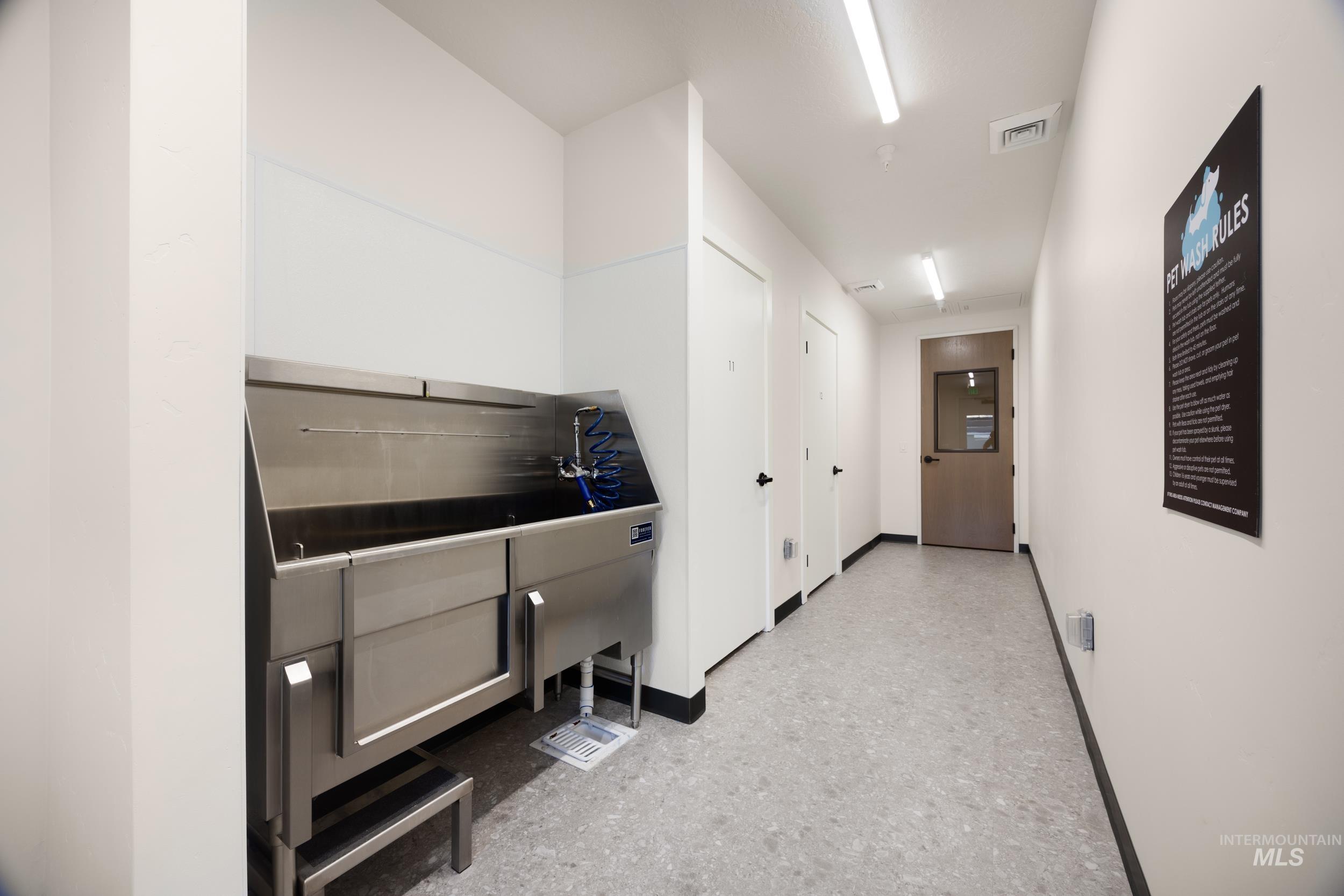 Miscellaneous room with pet washing station and baseboards