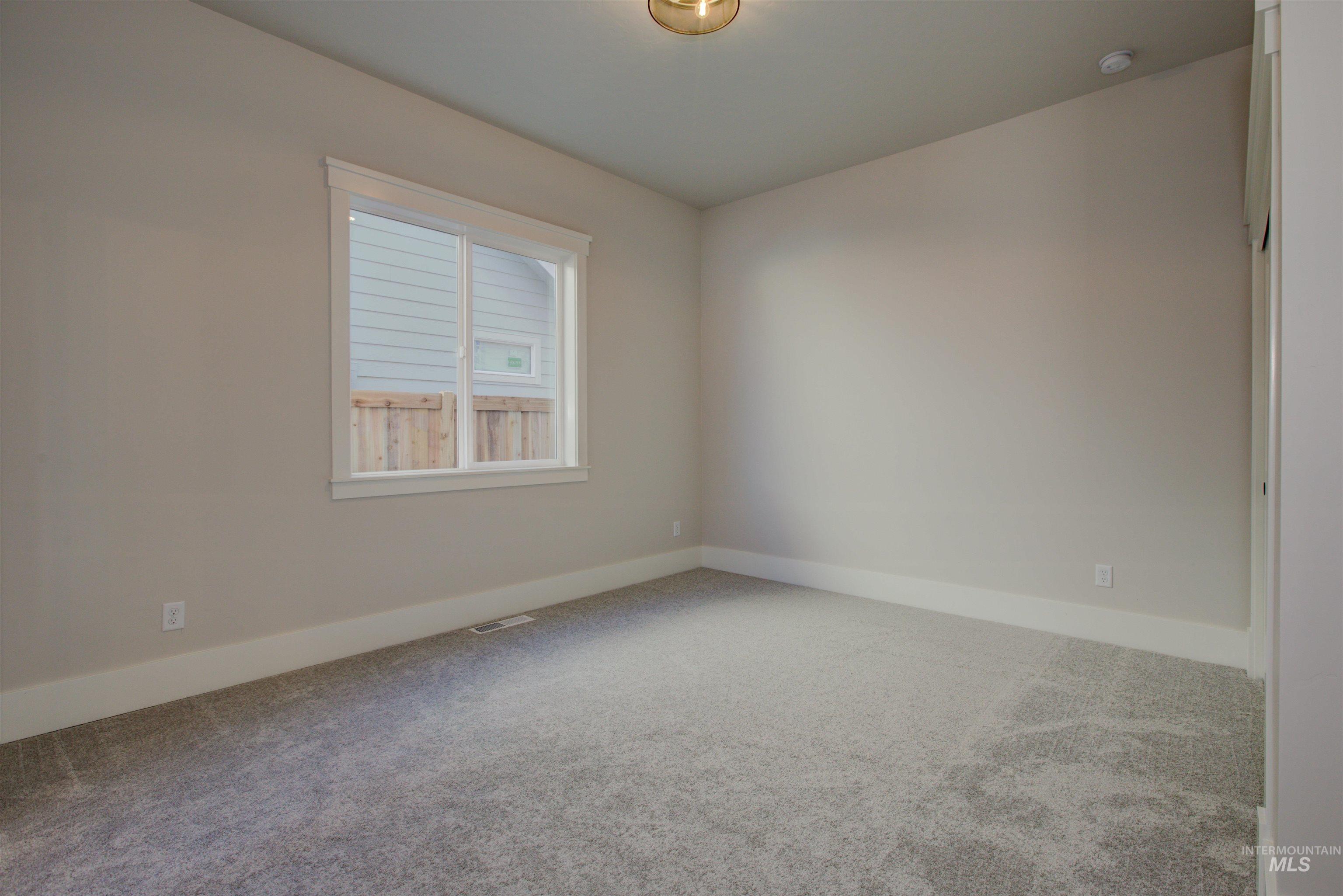 Carpeted empty room featuring baseboards