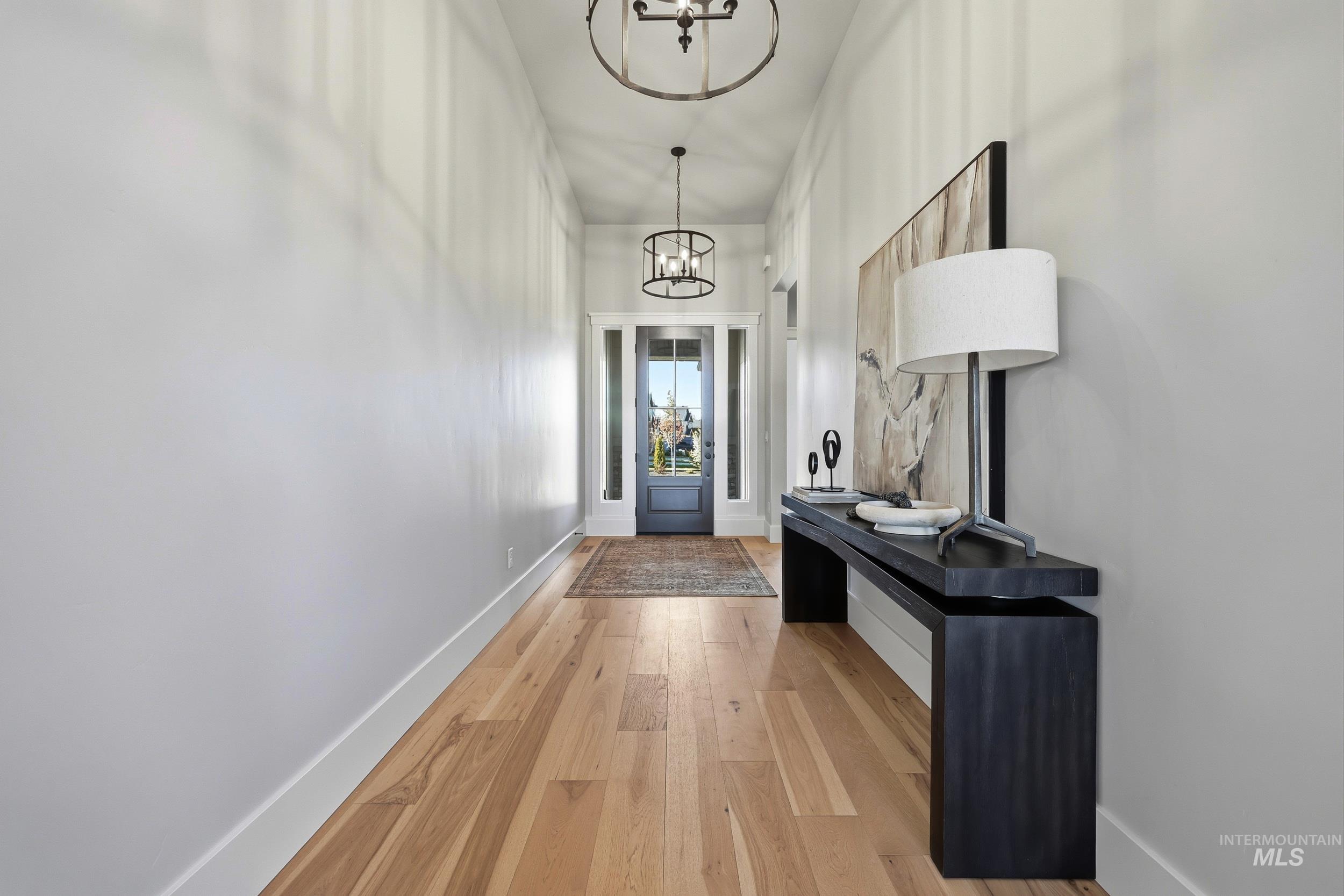 Doorway to outside featuring hardwood / wood-style flooring and a chandelier