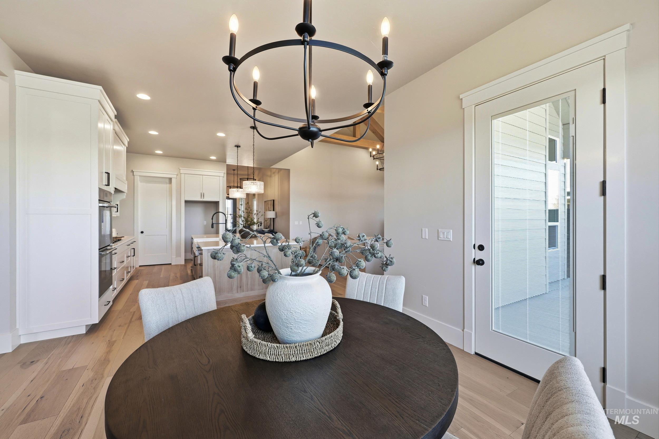Dining area with light wood-style floors, recessed lighting, and a chandelier
