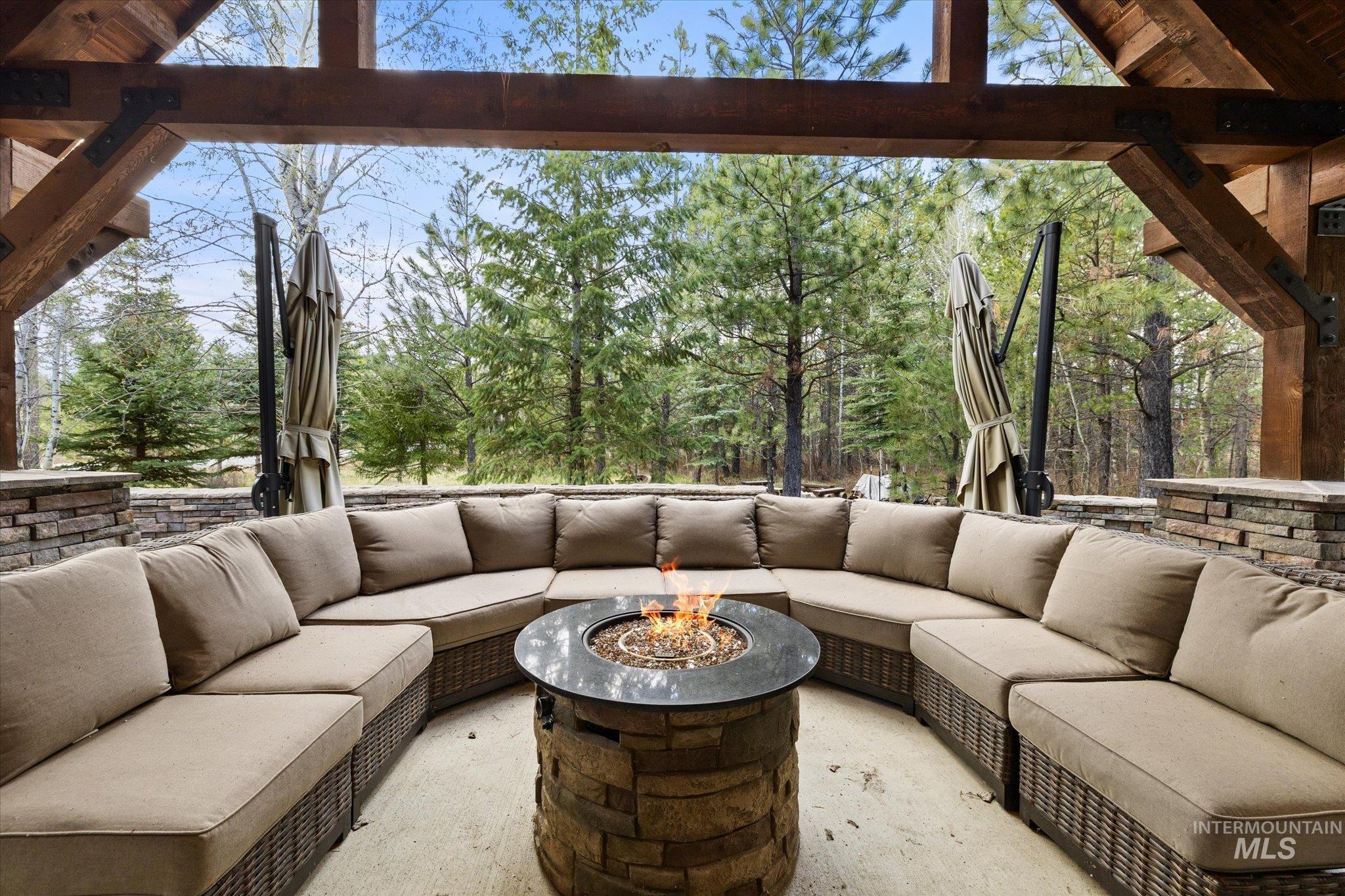 Covered outdoor patio featuring a stone-clad fire pit