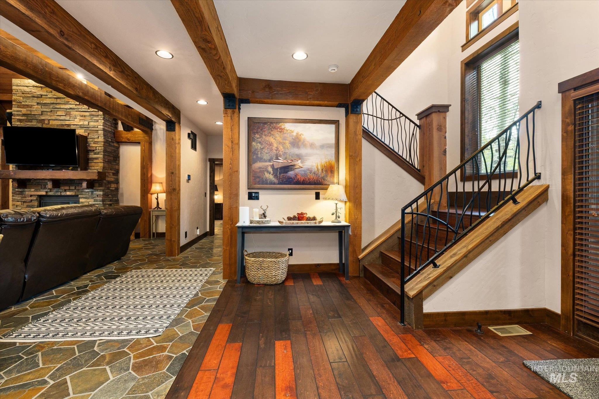 Entryway featuring wood-finish flooring with accent planks and a staircase with decorative wrought iron railing