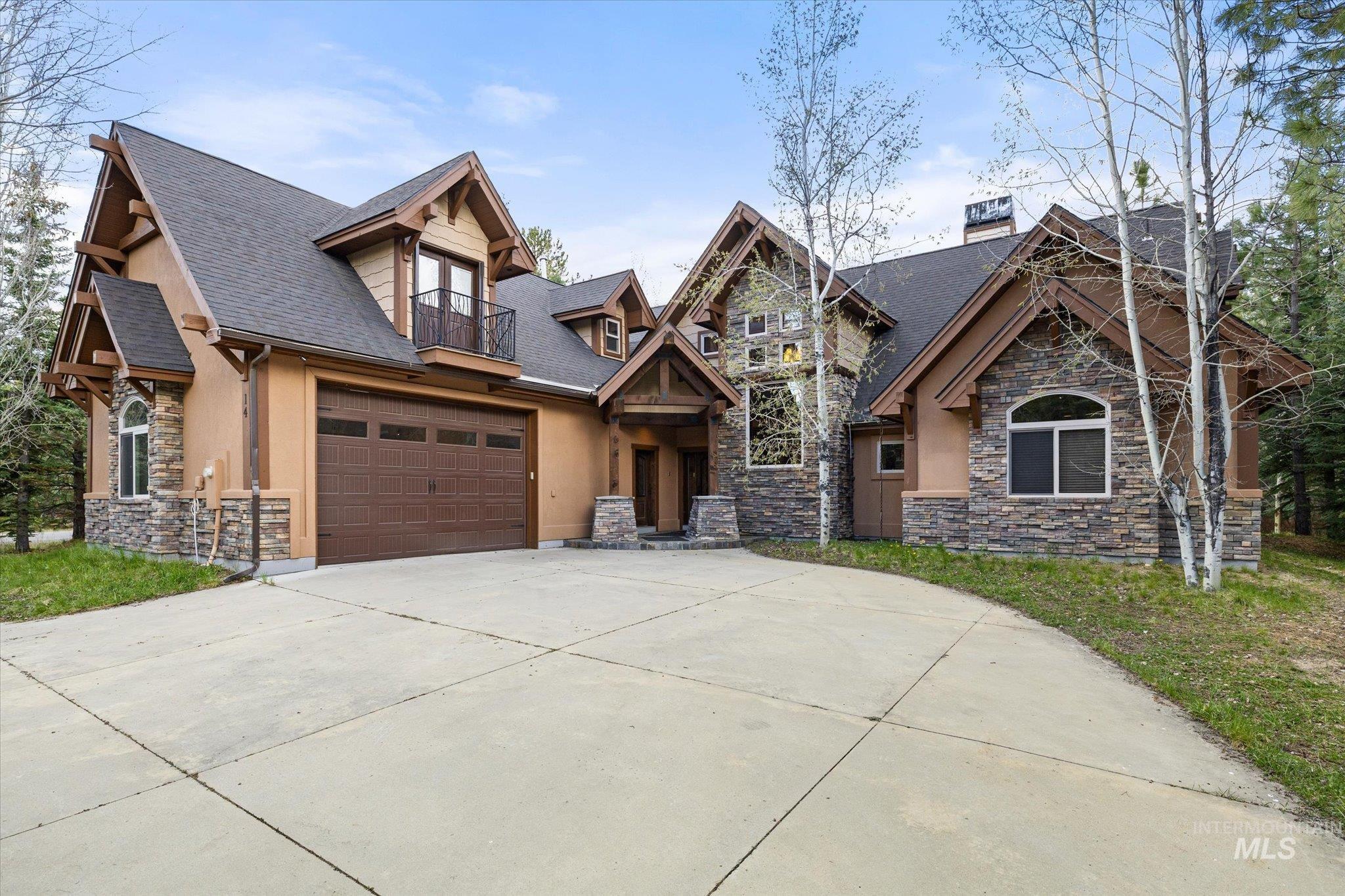Stone and stucco exterior with multiple gables and dark trim details