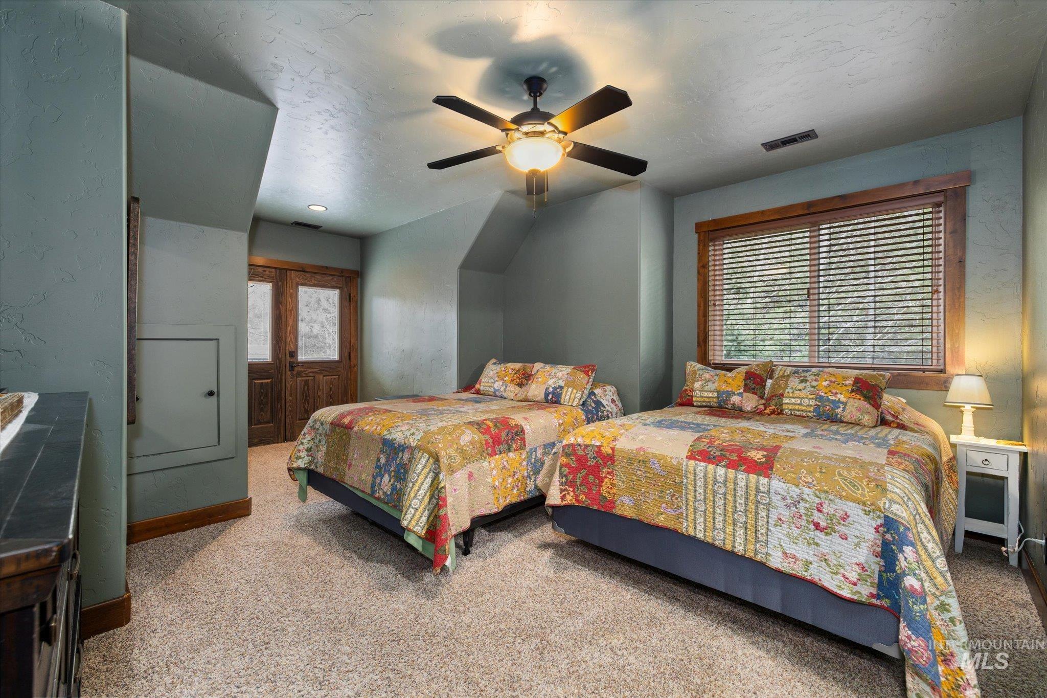Carpeted interior space featuring wood-finish window trim, a ceiling fan with integrated lighting, and painted walls