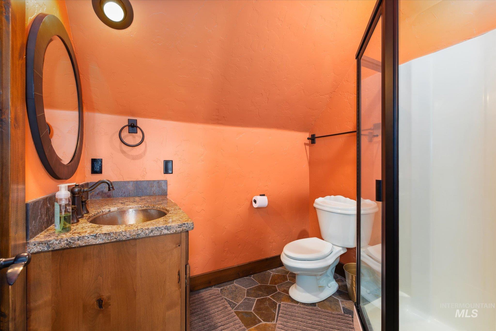Bathroom featuring a wood vanity with a granite countertop, undermount sink, and oil-rubbed bronze fixtures