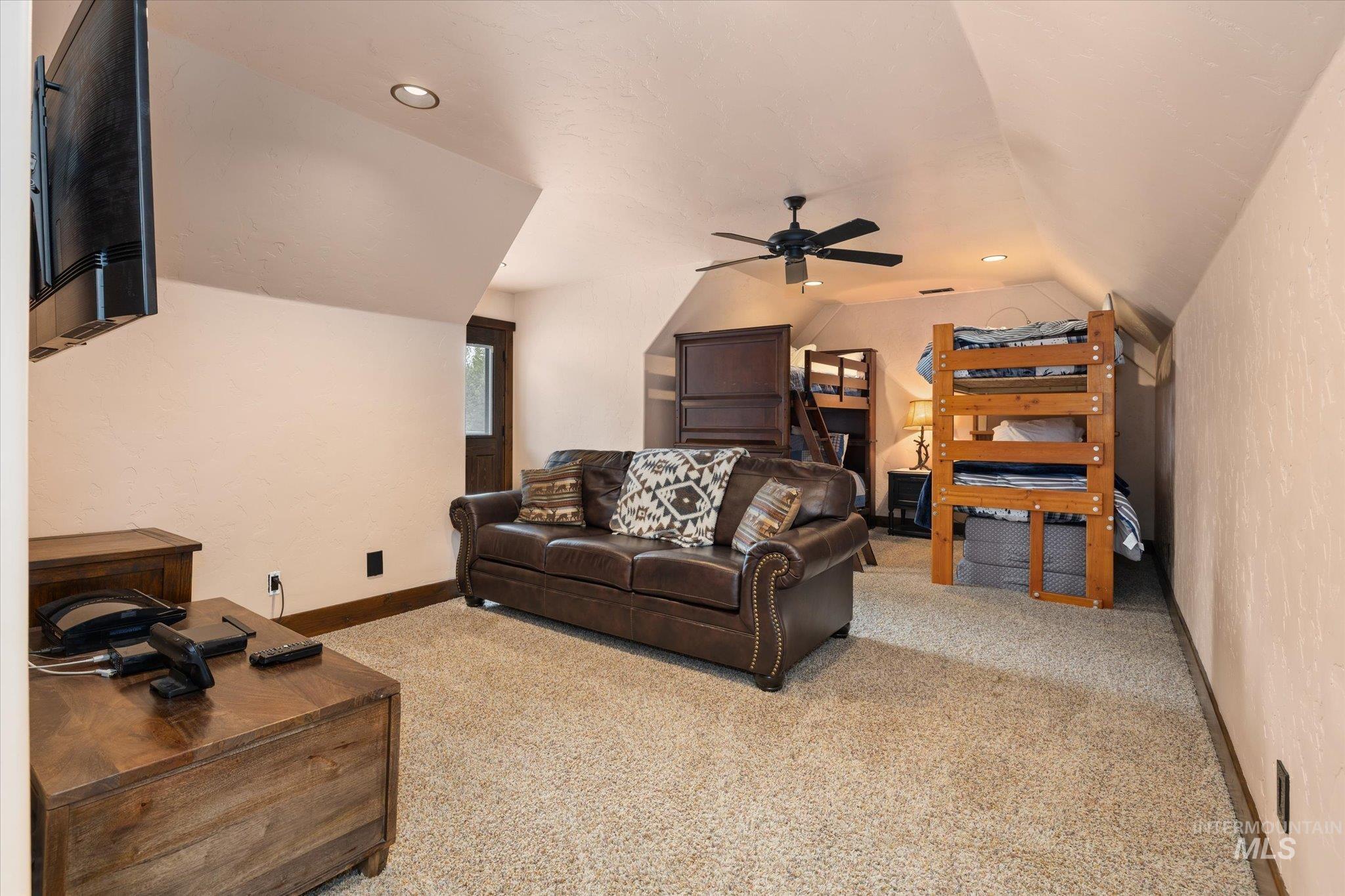 Carpeted room with sloped ceilings, recessed lighting, and a ceiling fan