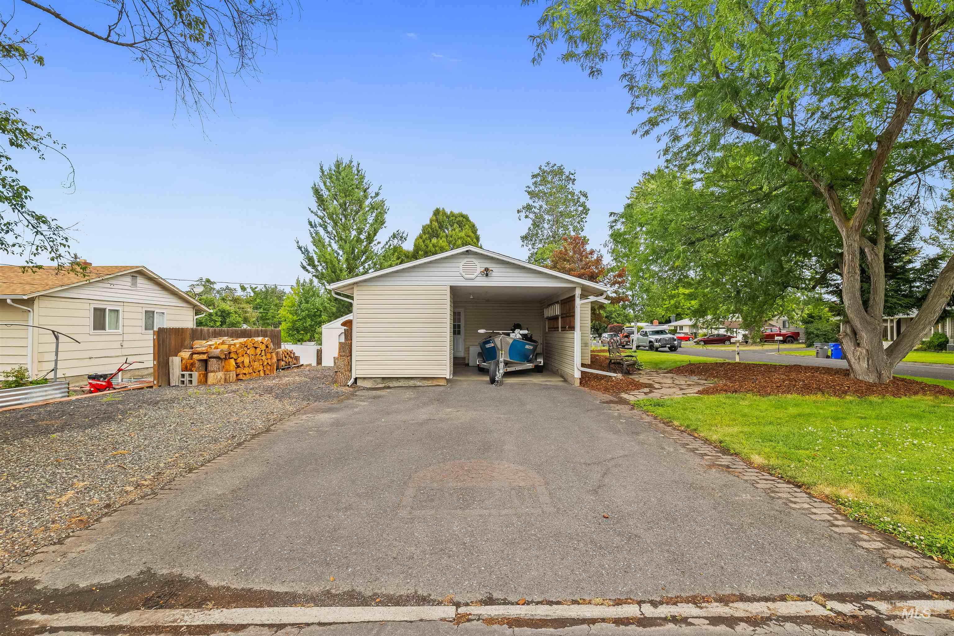 Carport structure featuring a pitched roof, vinyl siding, and ample covered parking