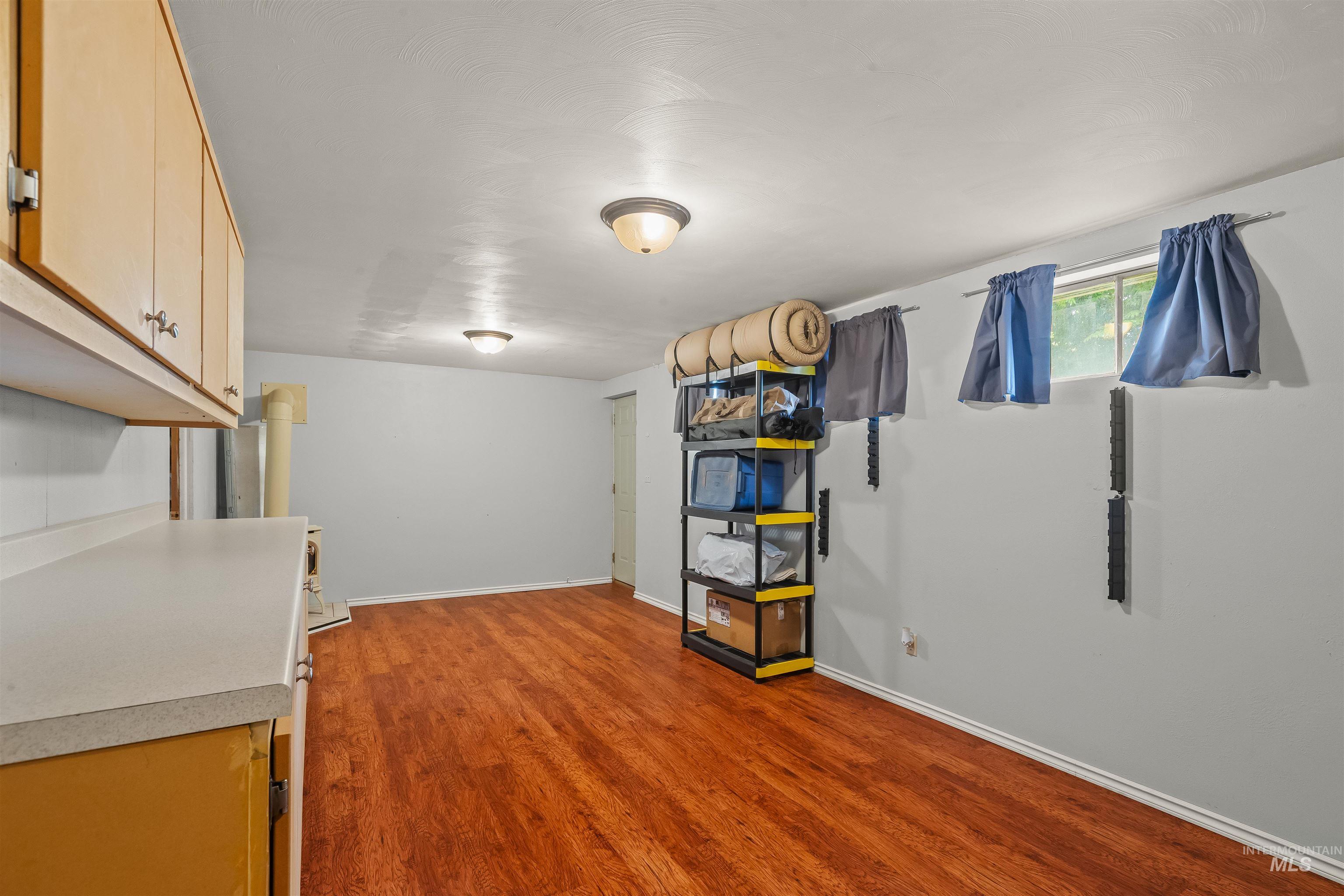 Finished room featuring wood-finish flooring, light grey walls, and a recessed window