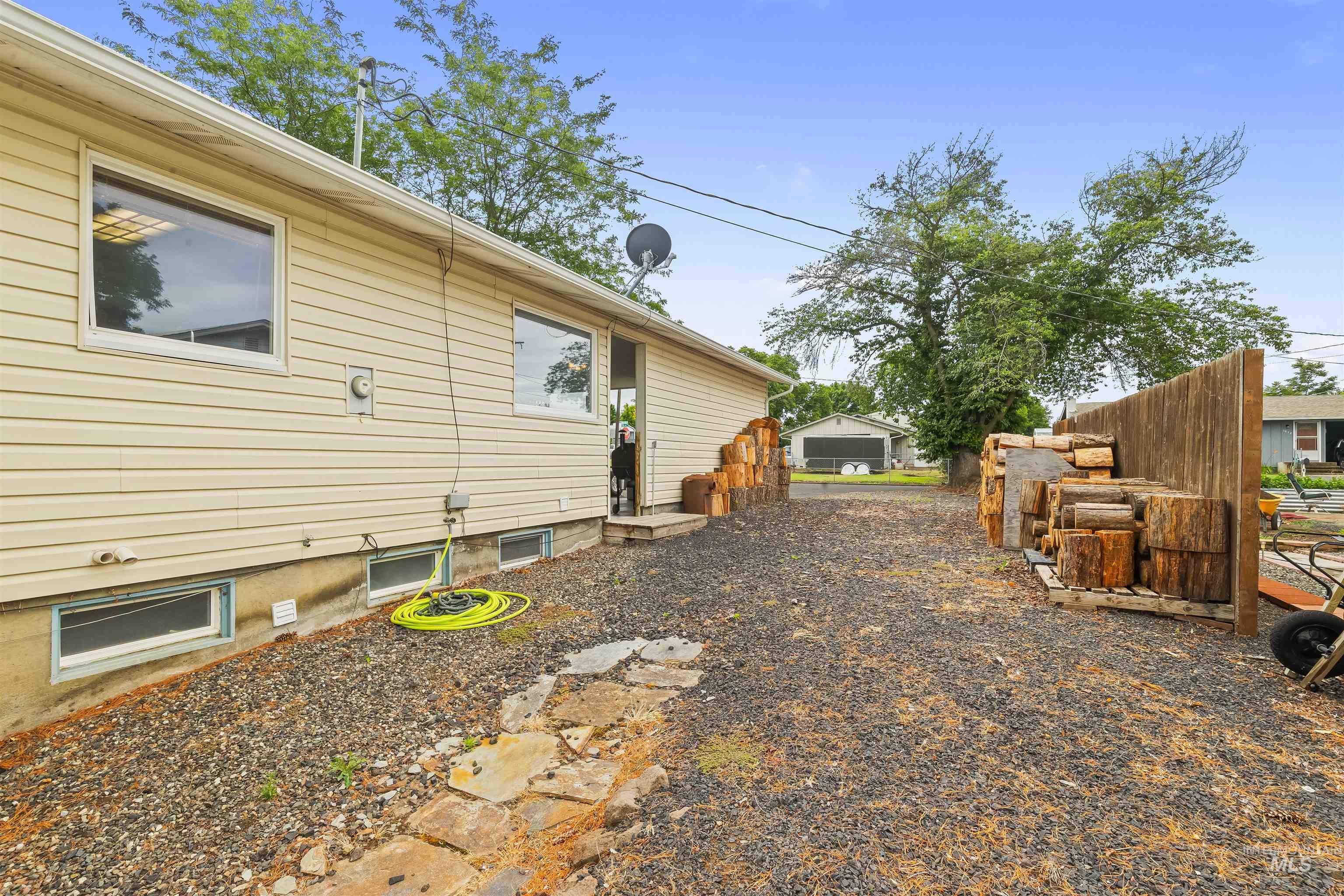Exterior siding with multiple windows and a gravel ground cover